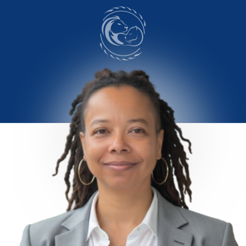 Smiling person with short curly hair wearing a gray blazer and yellow shirt, featuring hoop earrings.