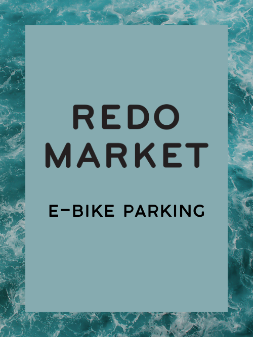Sign with text 'Redo Market E-Bike Parking' against a teal and ocean wave background.