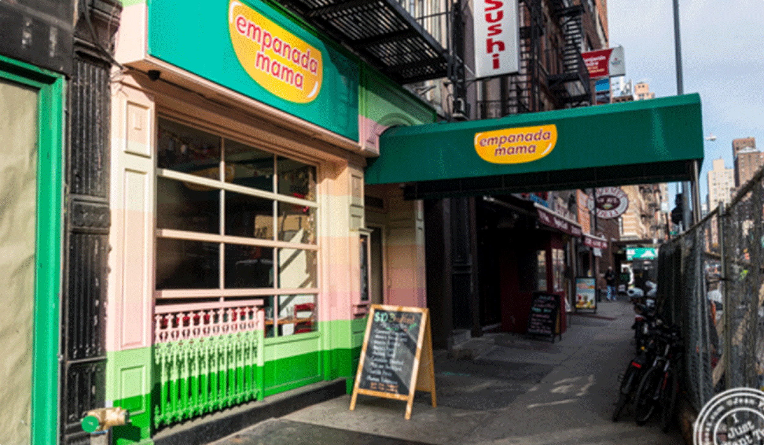 Empanada Mama restaurant storefront with green and pink signage on a city street.