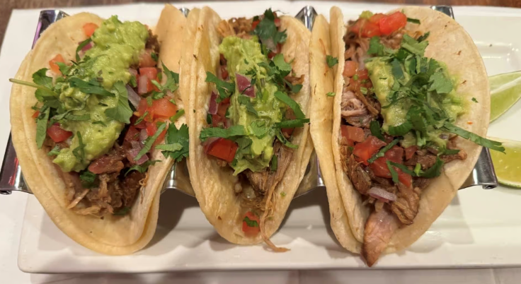 Trio of savory and sweet empanadas with garnish served on white plate at Empanada Mama in New York City.