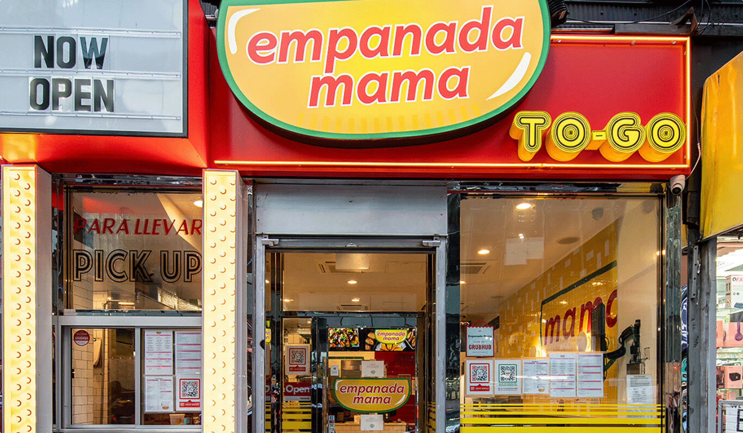 Empanada Mama to-go restaurant storefront with red and yellow signage and pickup window.