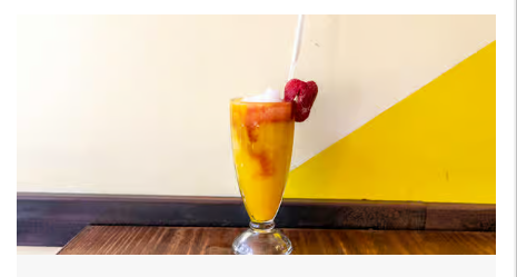 A refreshing strawberry shake served alongside a Colombian picada platter at Empanada Mama.