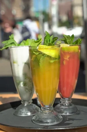 Empanada Mama trio of colorful mojito-style cocktails with mint and cucumber.