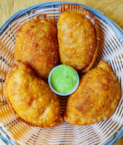 Empanada Mama basket of crispy golden empanadas with green dipping sauce.