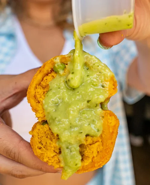 Empanada Mama curry chicken empanada topped with green sauce.