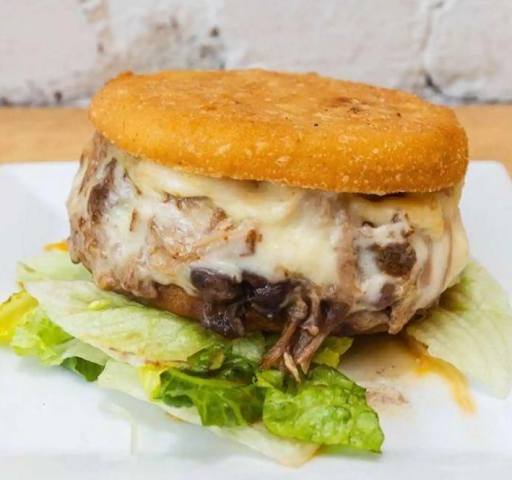 Cubana arepa from Empanada Mama filled with savory meat, melted cheese, and fresh toppings.