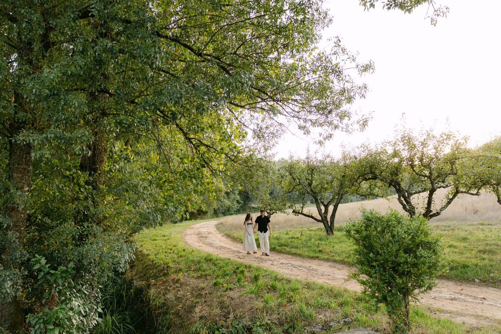 Newly engaged couple walking together through the countryside at Quinta de Sant’Ana in Portugal after their surprise proposal.