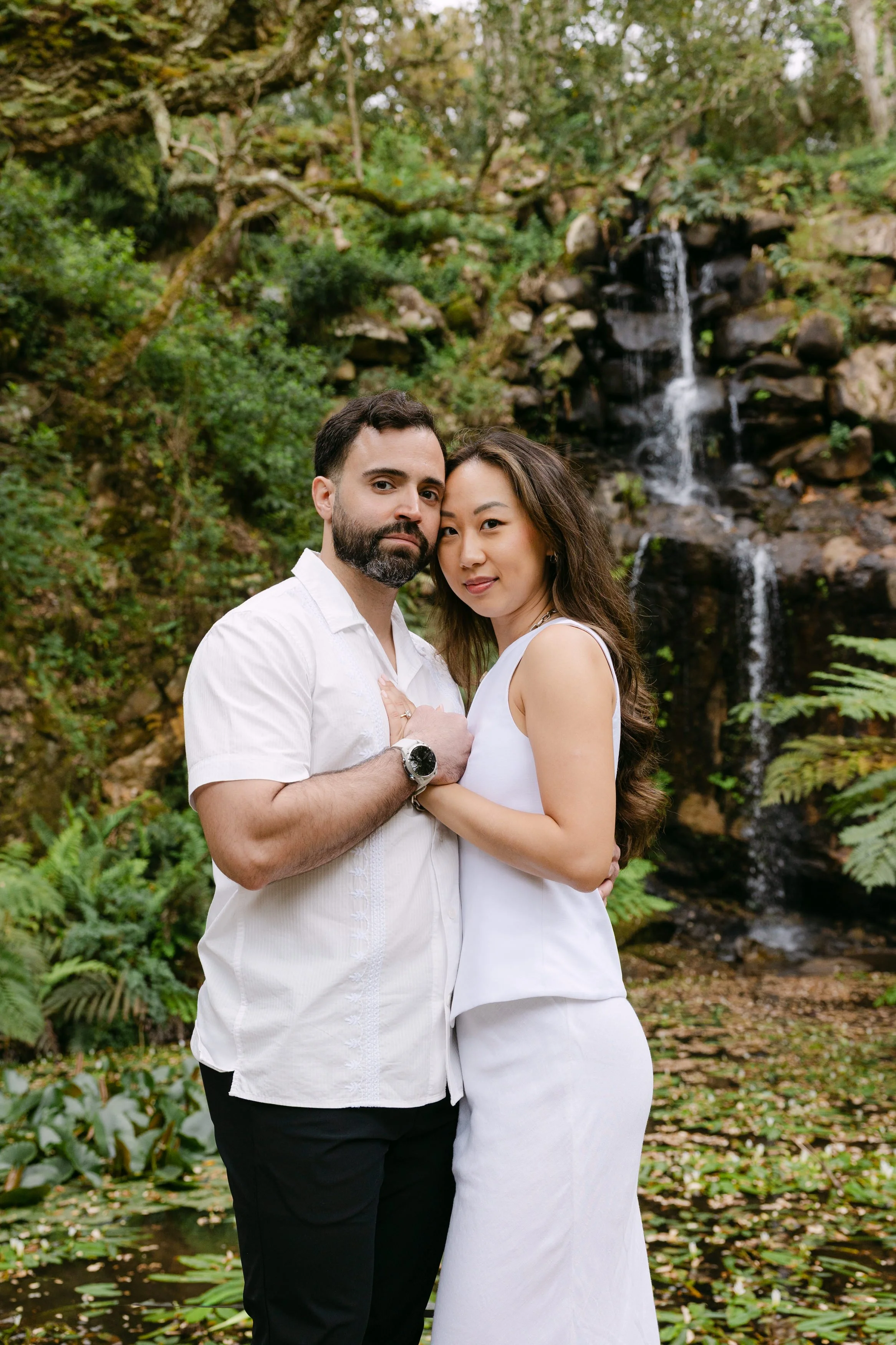 Couple embracing in front of waterfall during Monserrate engagement session in Portugal.