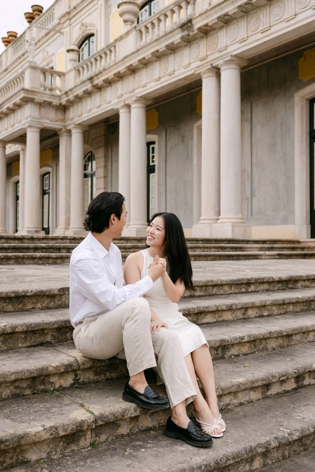 Couple laughing together during engagement session at Palácio de Queluz, Portugal.