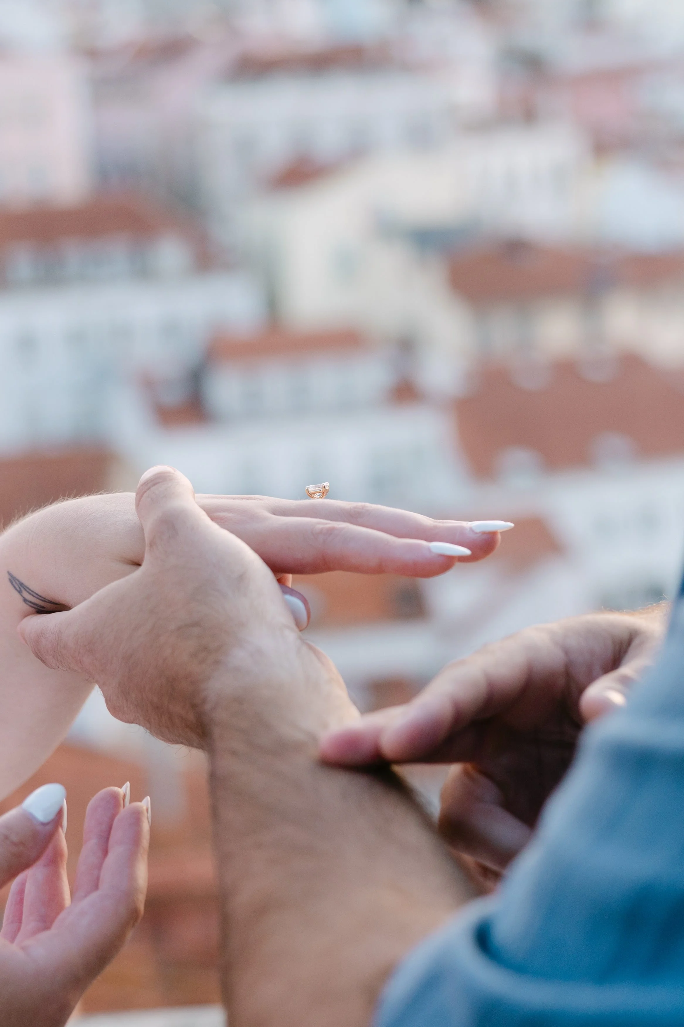 Newly engaged couple admiring the engagement ring after their sunrise proposal in Lisbon.