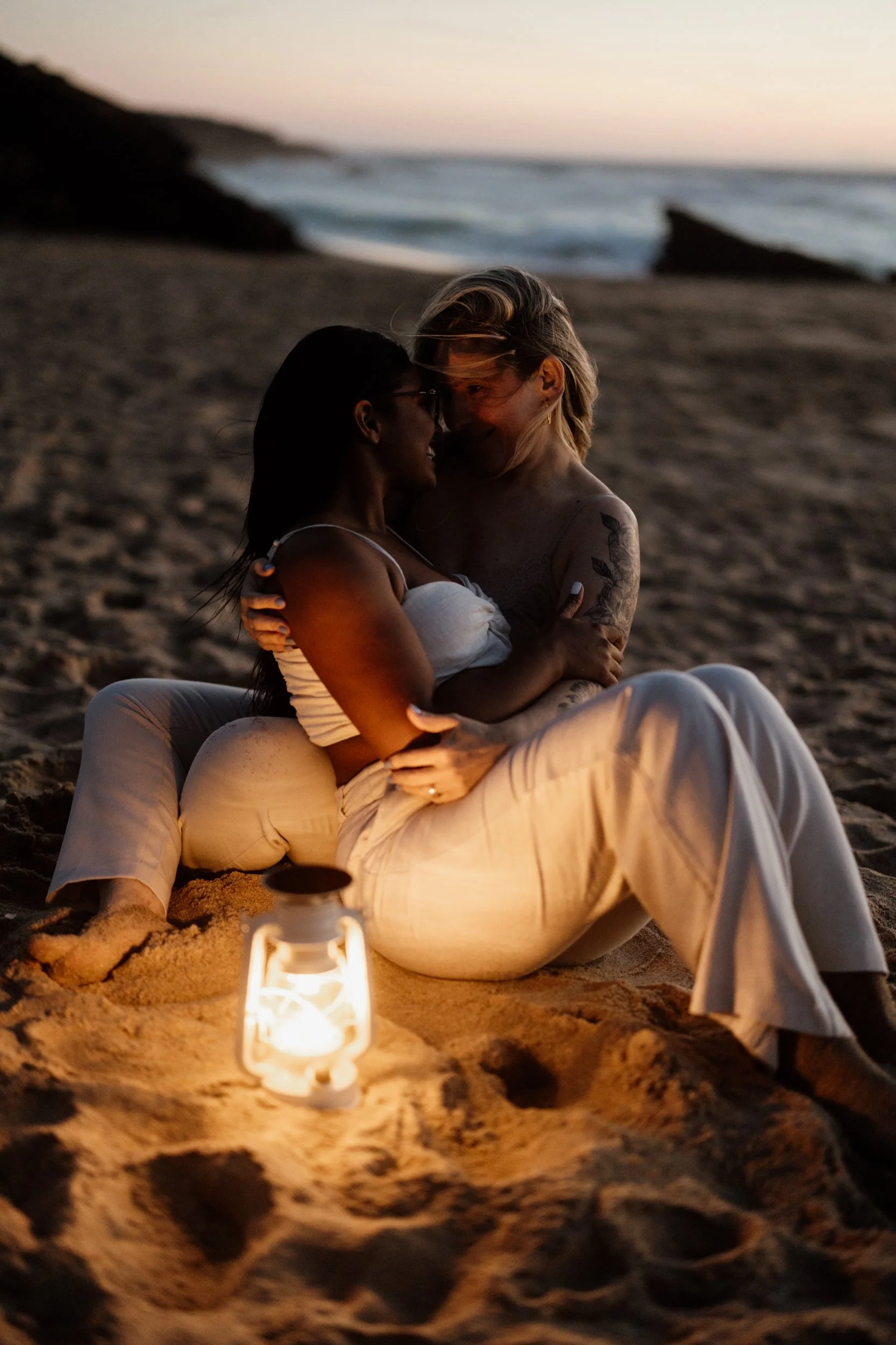 Couple lgbtq embracing during sunset beach engagement in Portugal