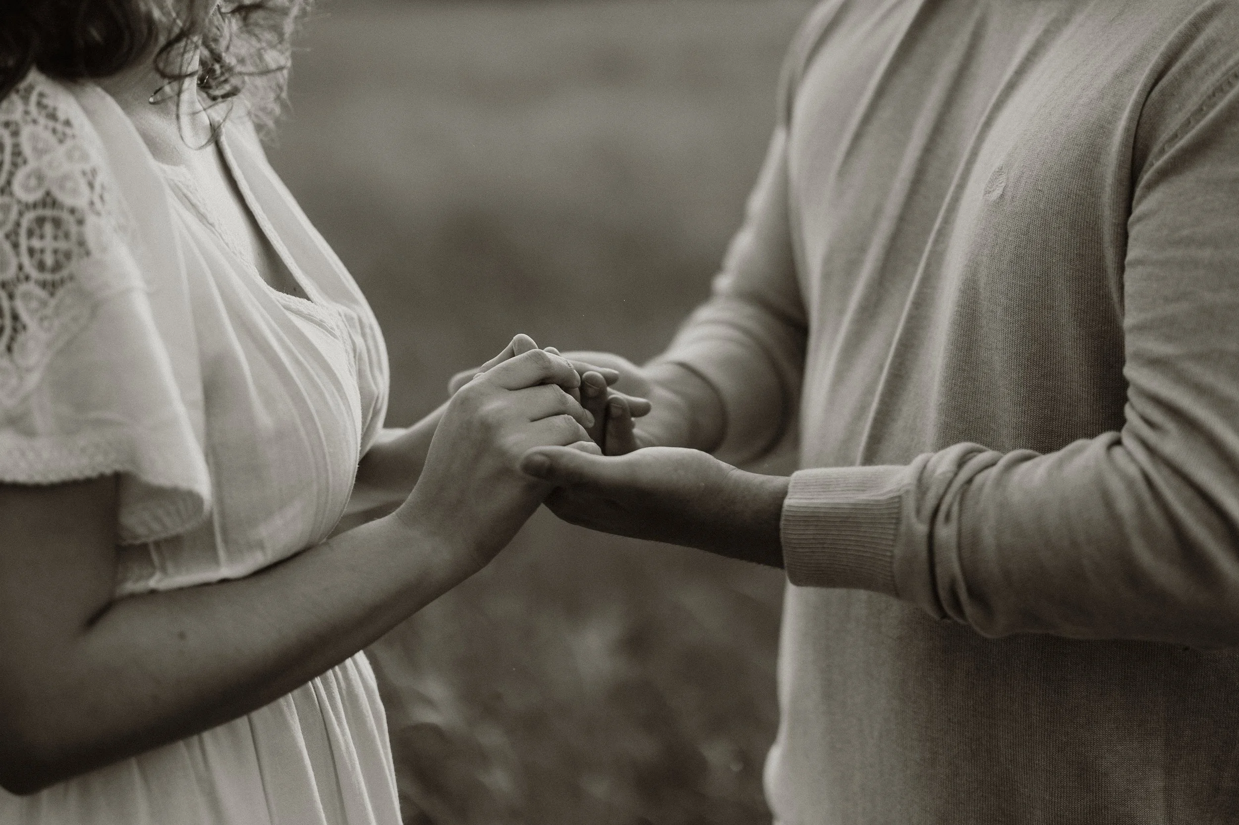 Close-up photograph of a couple holding hands during a romantic engagement session in Lisbon, Portugal.