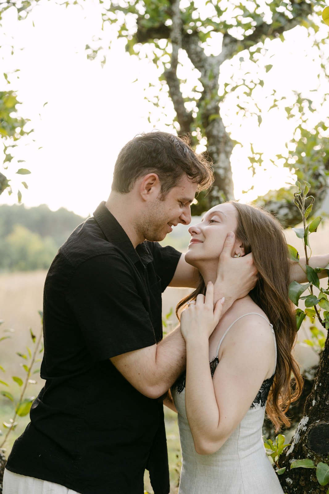Newly engaged couple embracing beneath the trees during a relaxed engagement session at Quinta de Sant’Ana.