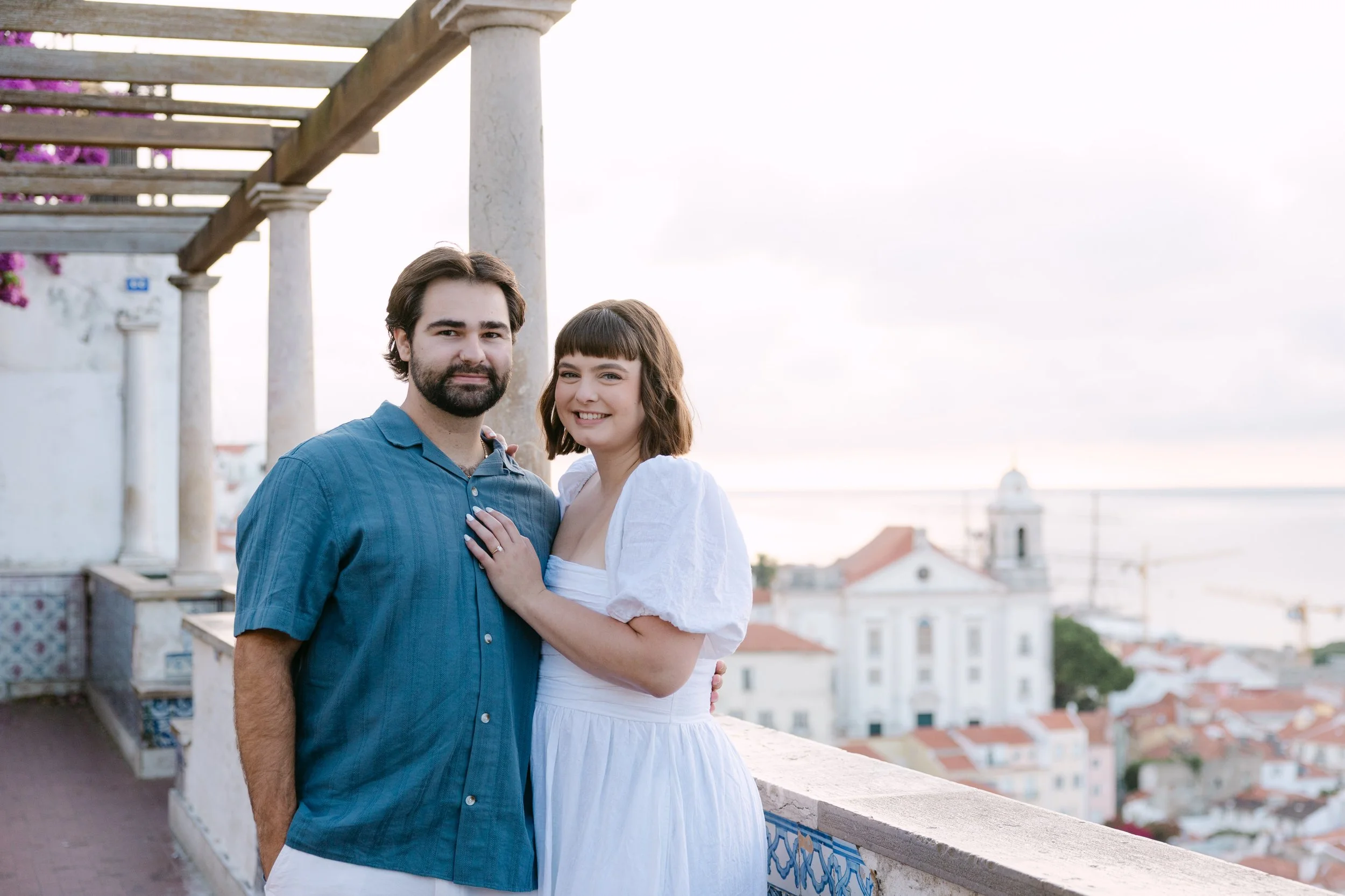 Newly engaged couple photographed at Miradouro de Santa Luzia after their sunrise proposal in Lisbon.