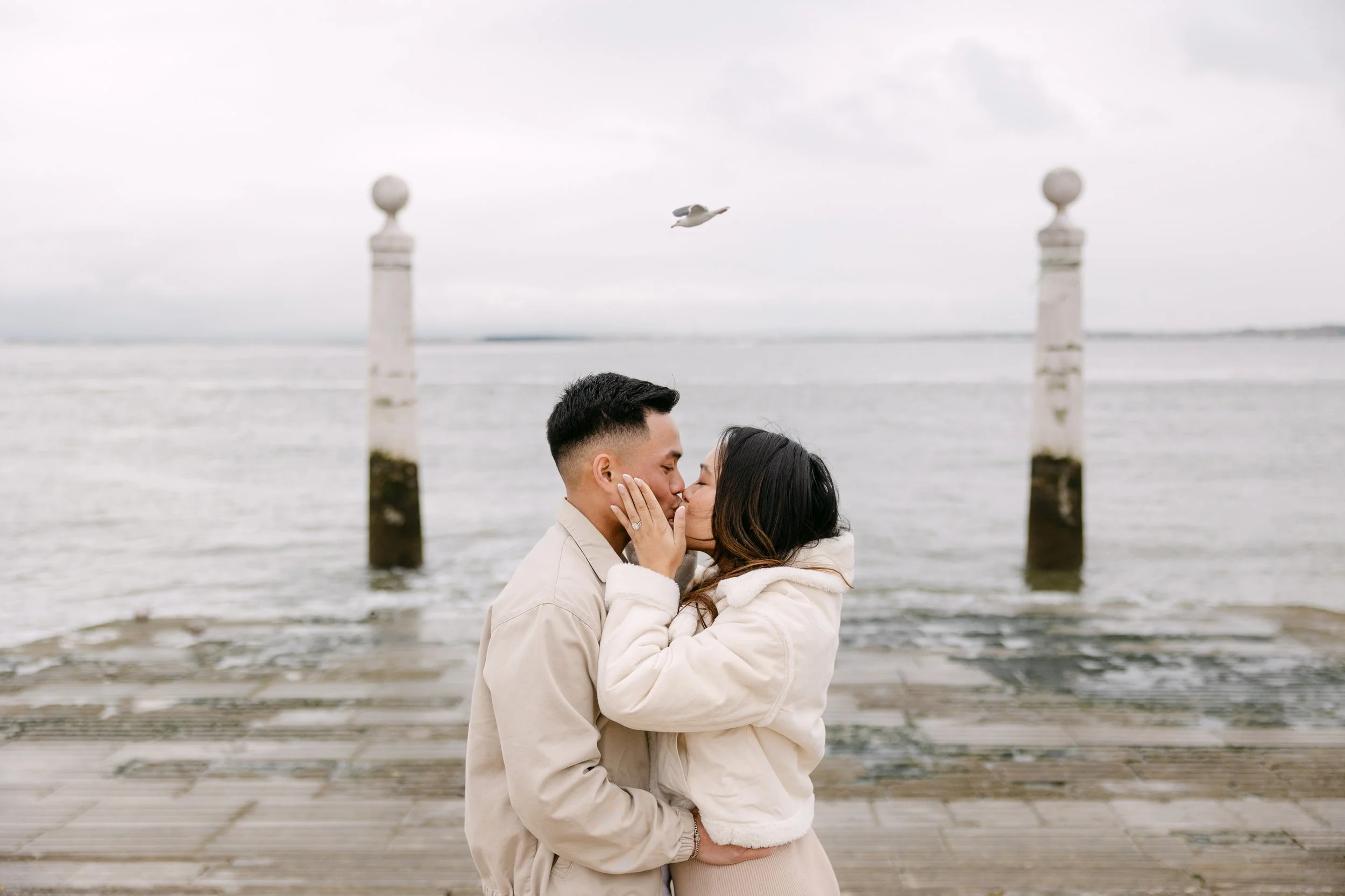 Engaged couple kissing at Cais das Colunas in Lisbon Portugal