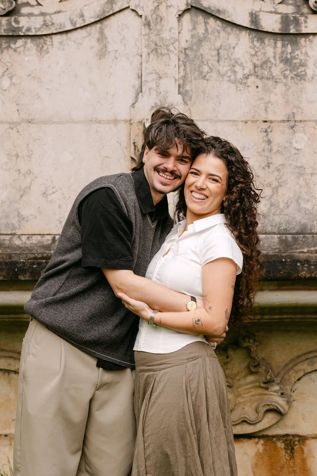 Engaged couple smiling together during a proposal photoshoot at Tapada das Necessidades