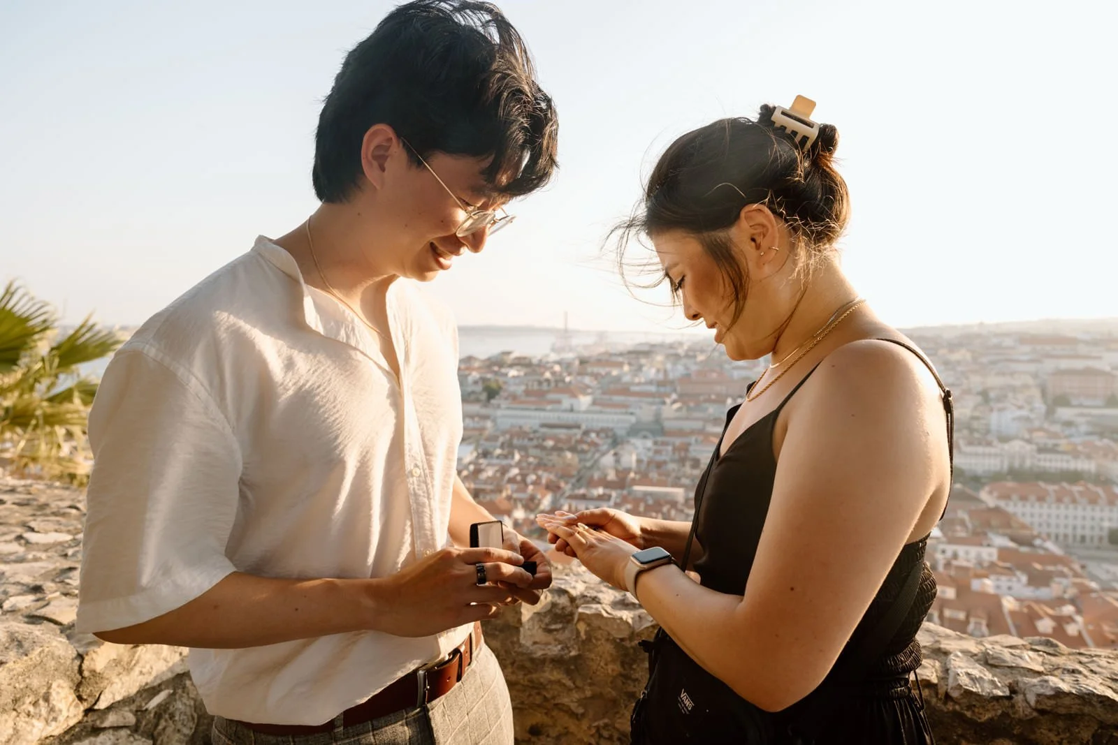 Just engaged couple admiring their engagement ring at Castelo de São Jorge overlooking Lisbon.