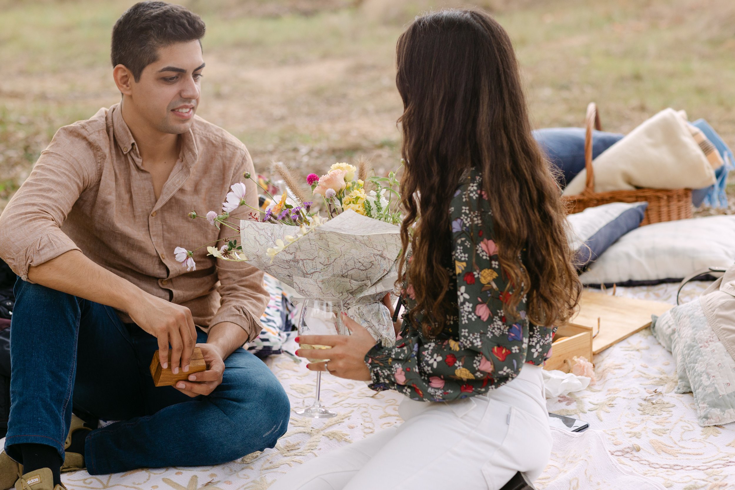 Couple talking during romantic vineyard picnic after proposal