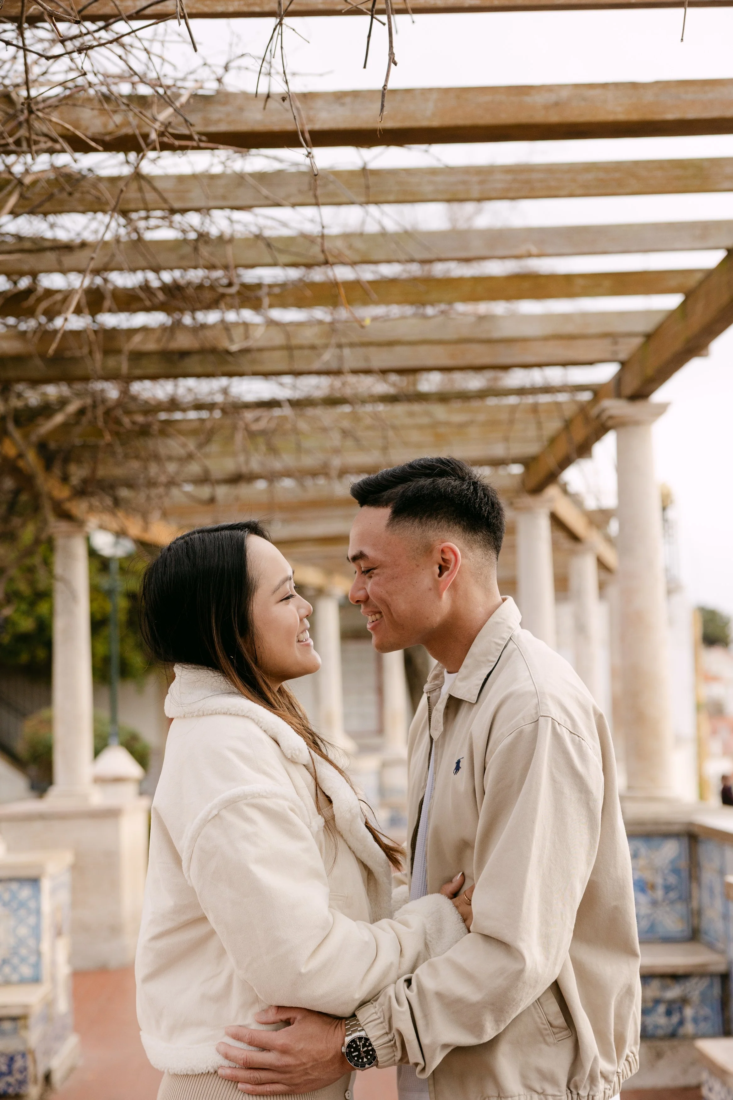 Couple embracing during engagement session at Miradouro de Santa Luzia