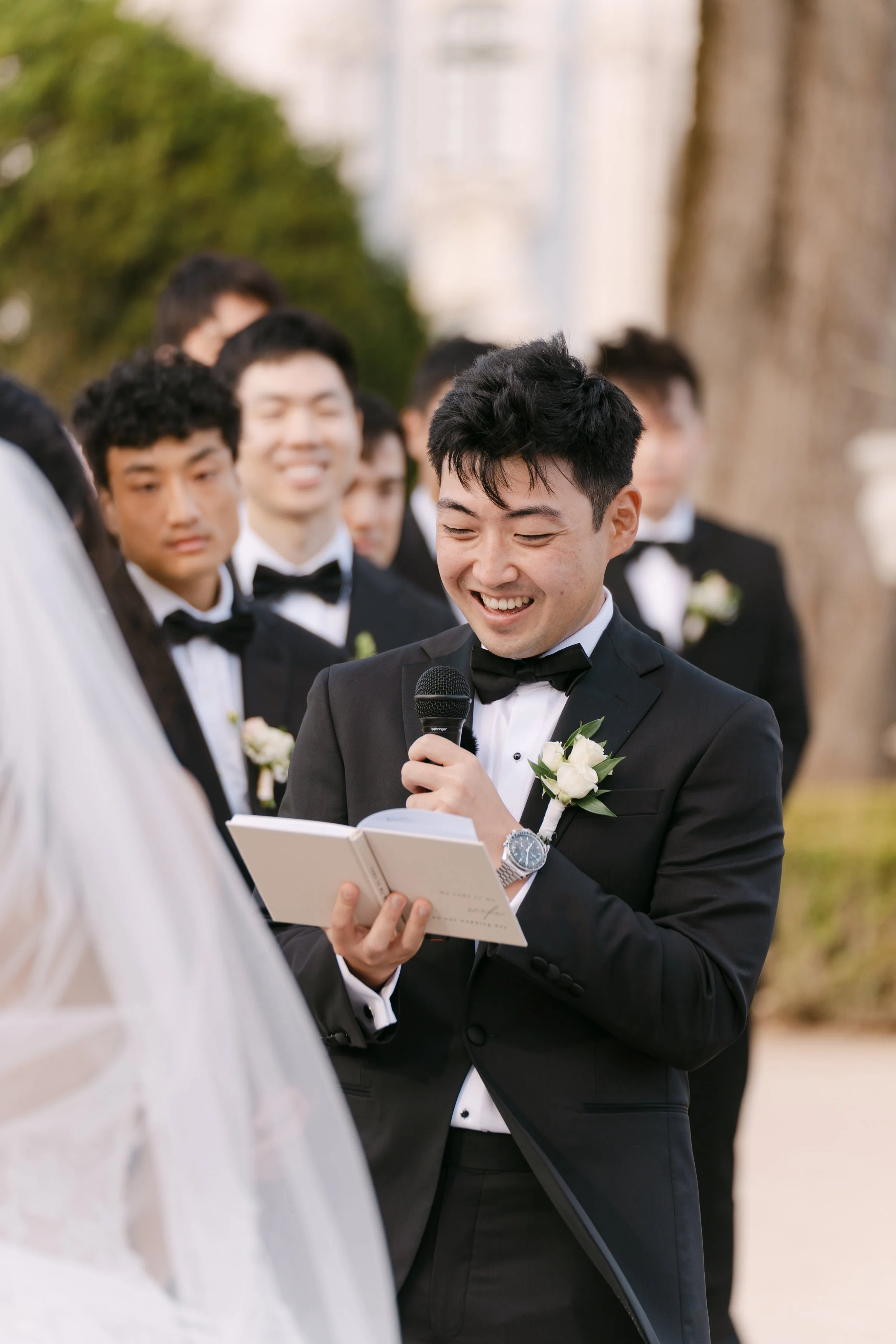 Groom smiling as he reads his handwritten vows to the bride during their garden wedding ceremony at Palácio Nacional de Queluz.