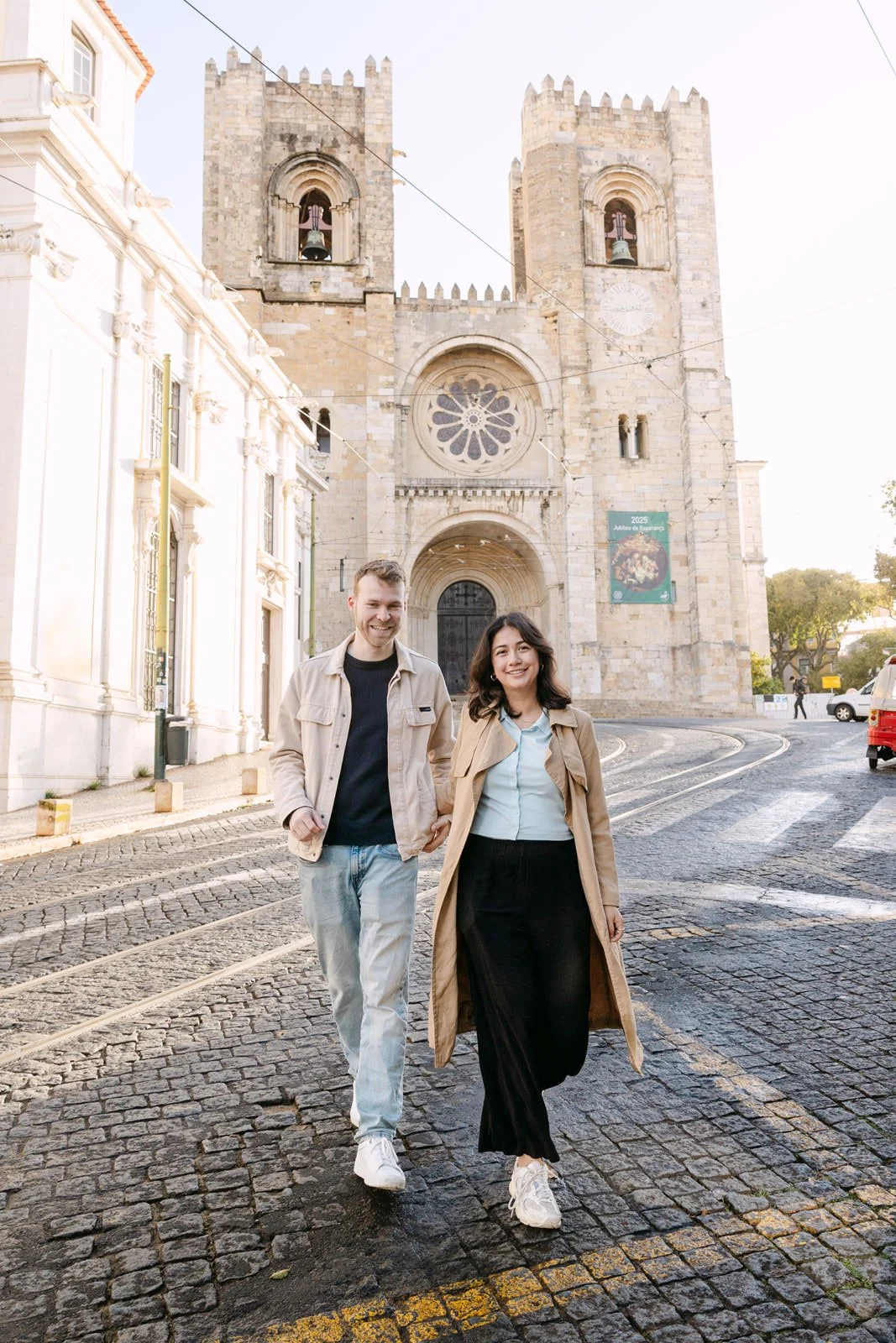 Engaged couple walking in front of Lisbon Cathedral during an engagement session