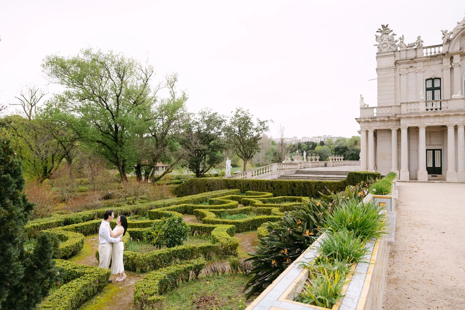 Couple sitting on the palace steps during engagement photos at Palácio de Queluz.