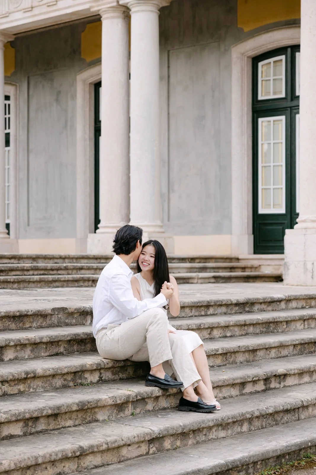 Couple laughing together during engagement session at Palácio de Queluz, Portugal.