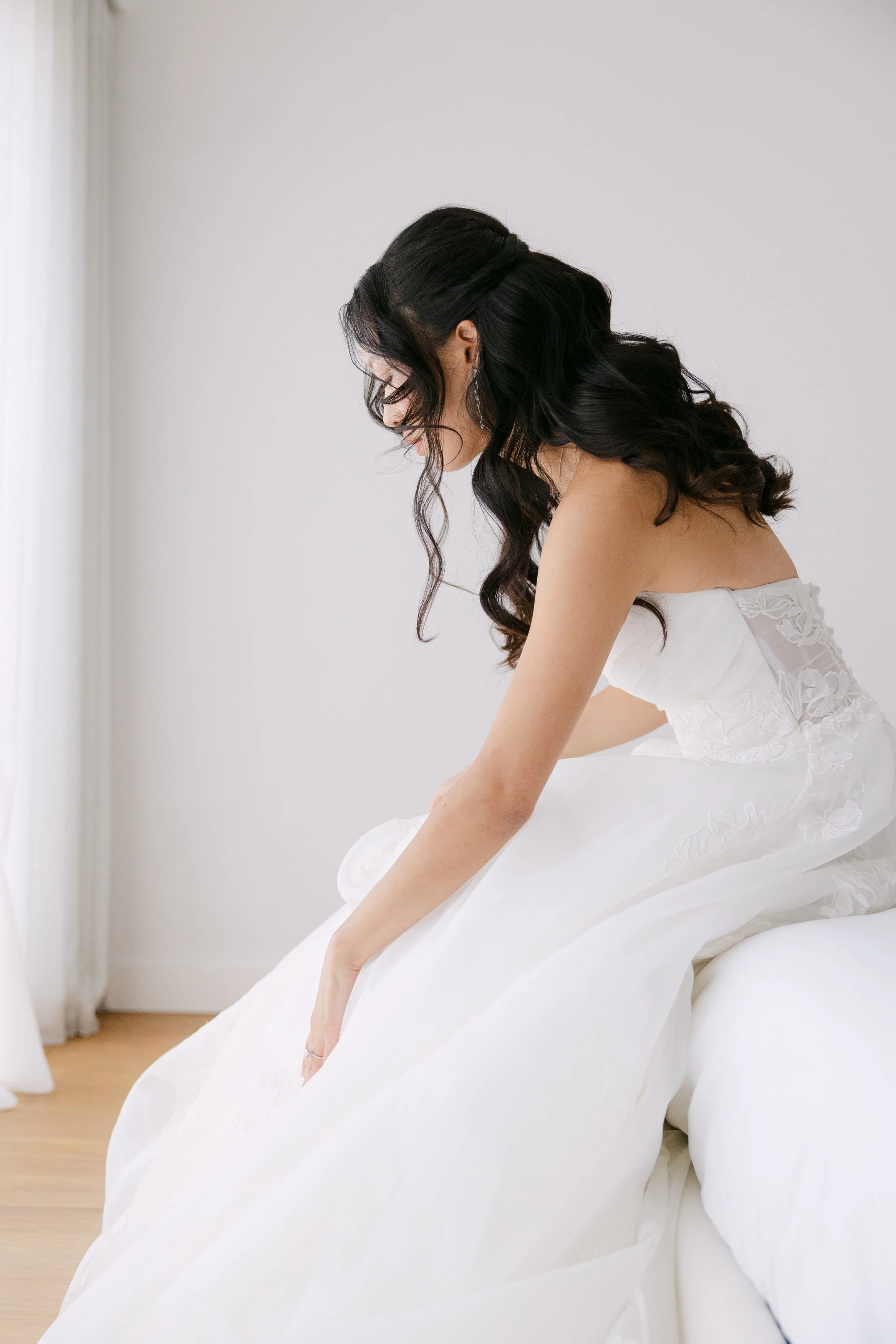 Bride getting into her white wedding dress during quiet morning preparations before her wedding at Palácio Nacional de Queluz.
