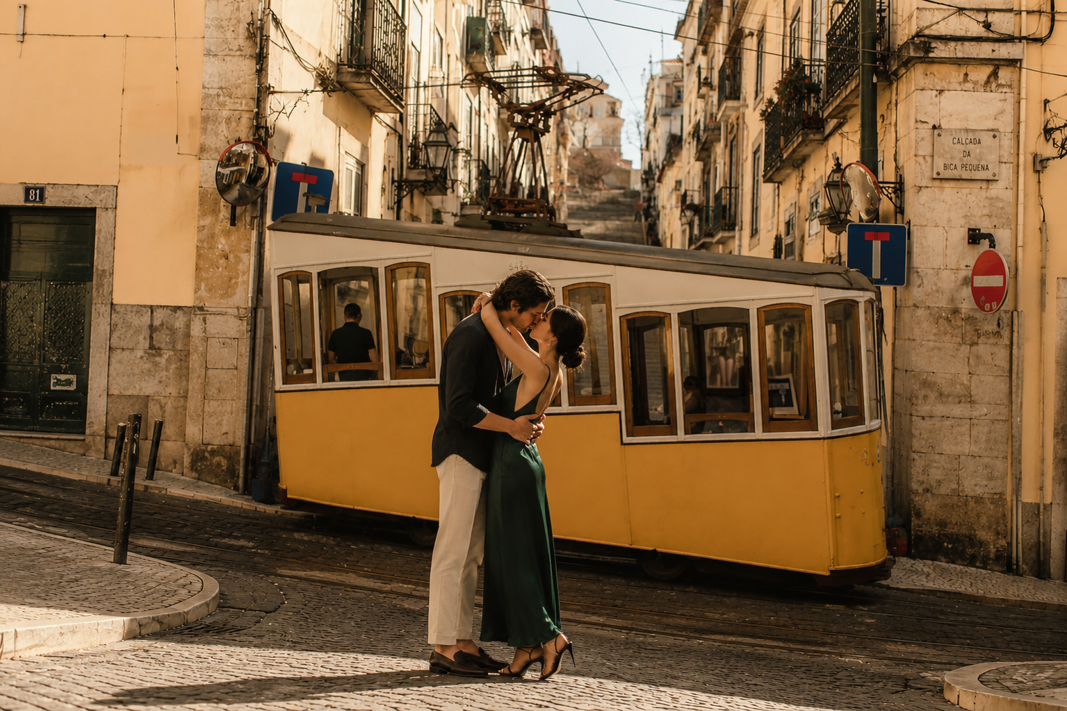 Couple embracing beside Lisbon's iconic yellow Tram 28 during an engagement session in Baixa-Chiado.