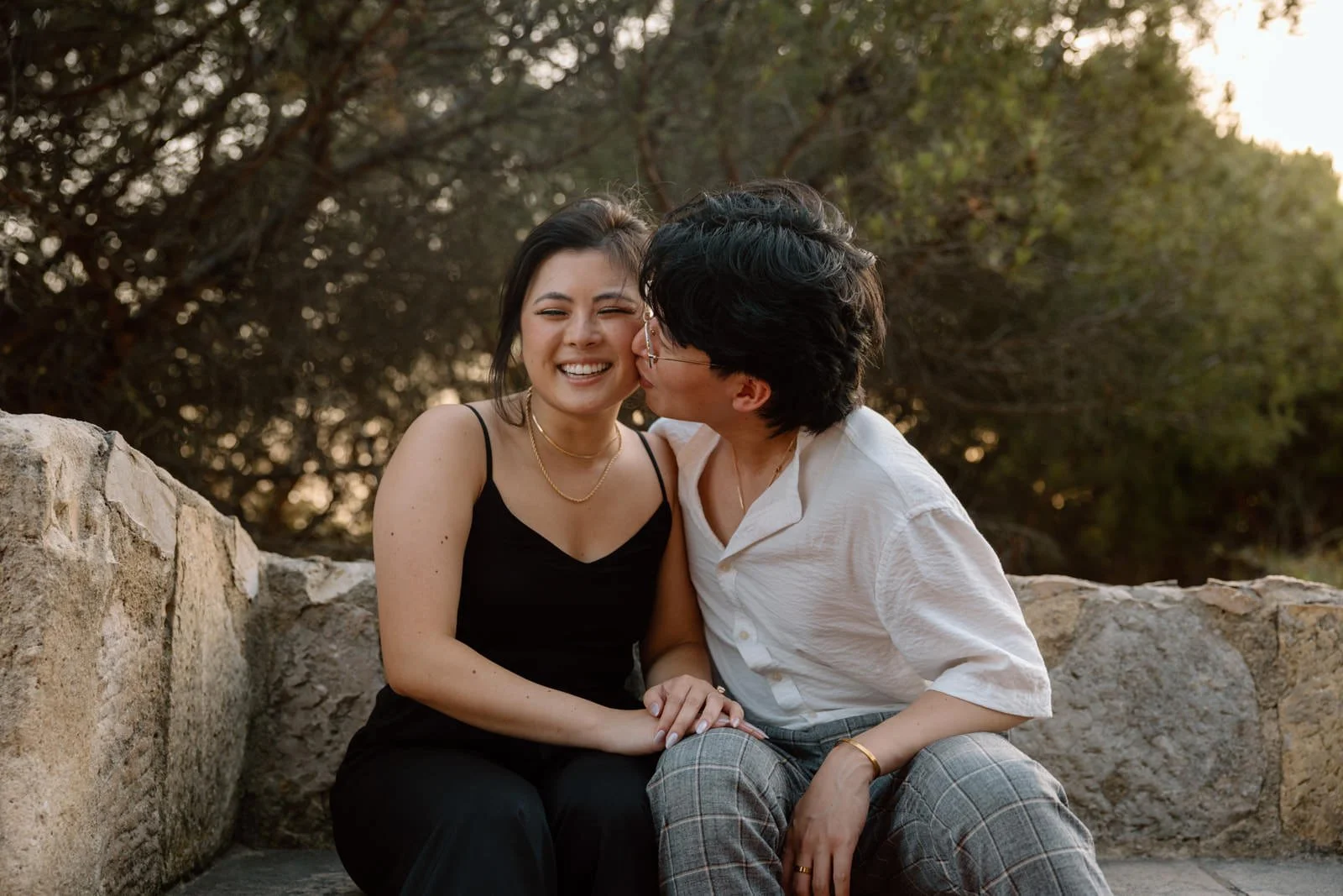 Couple celebrating their engagement at Castelo de São Jorge during a sunset photo session overlooking Lisbon.