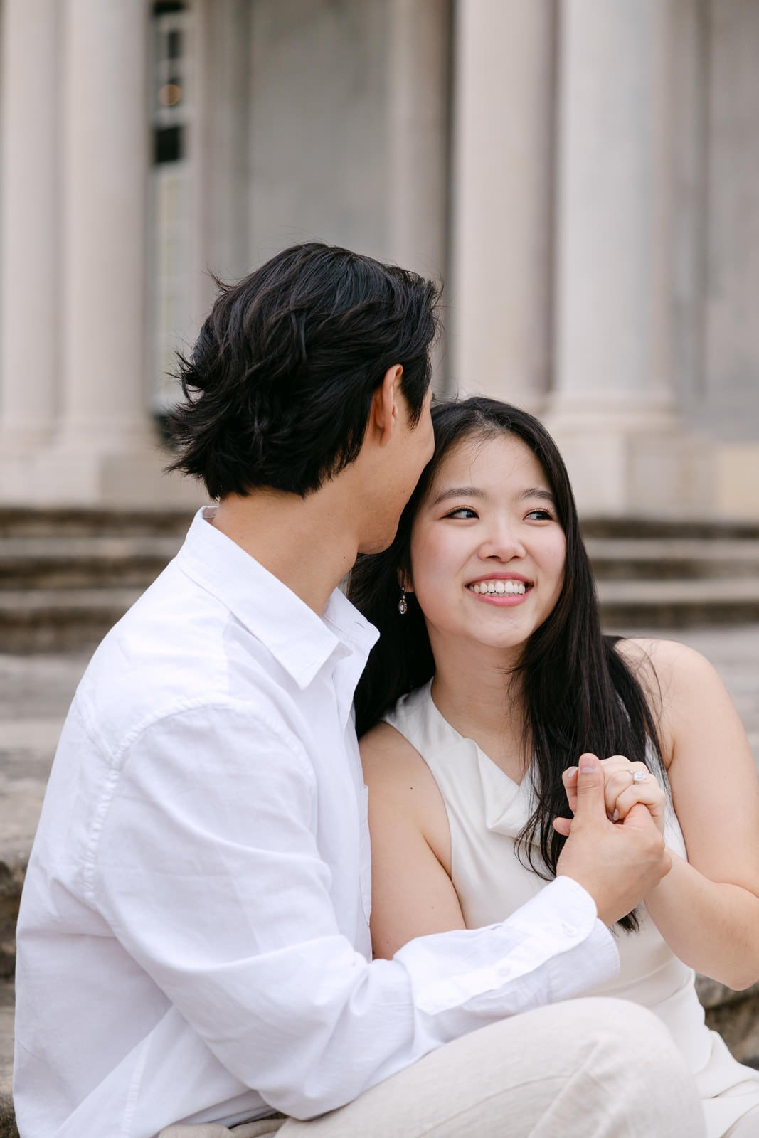 Couple sitting on the palace steps during engagement photos at Palácio de Queluz.