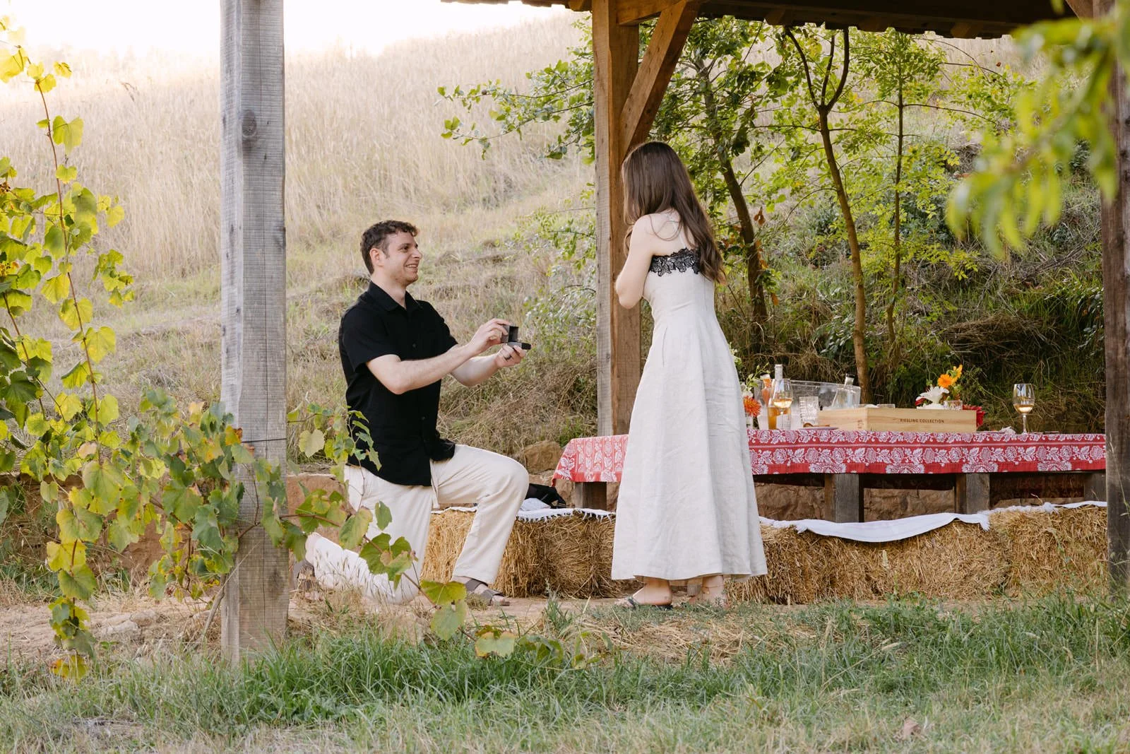 Man proposing with an engagement ring during a romantic countryside picnic at Quinta de Sant’Ana near Lisbon.