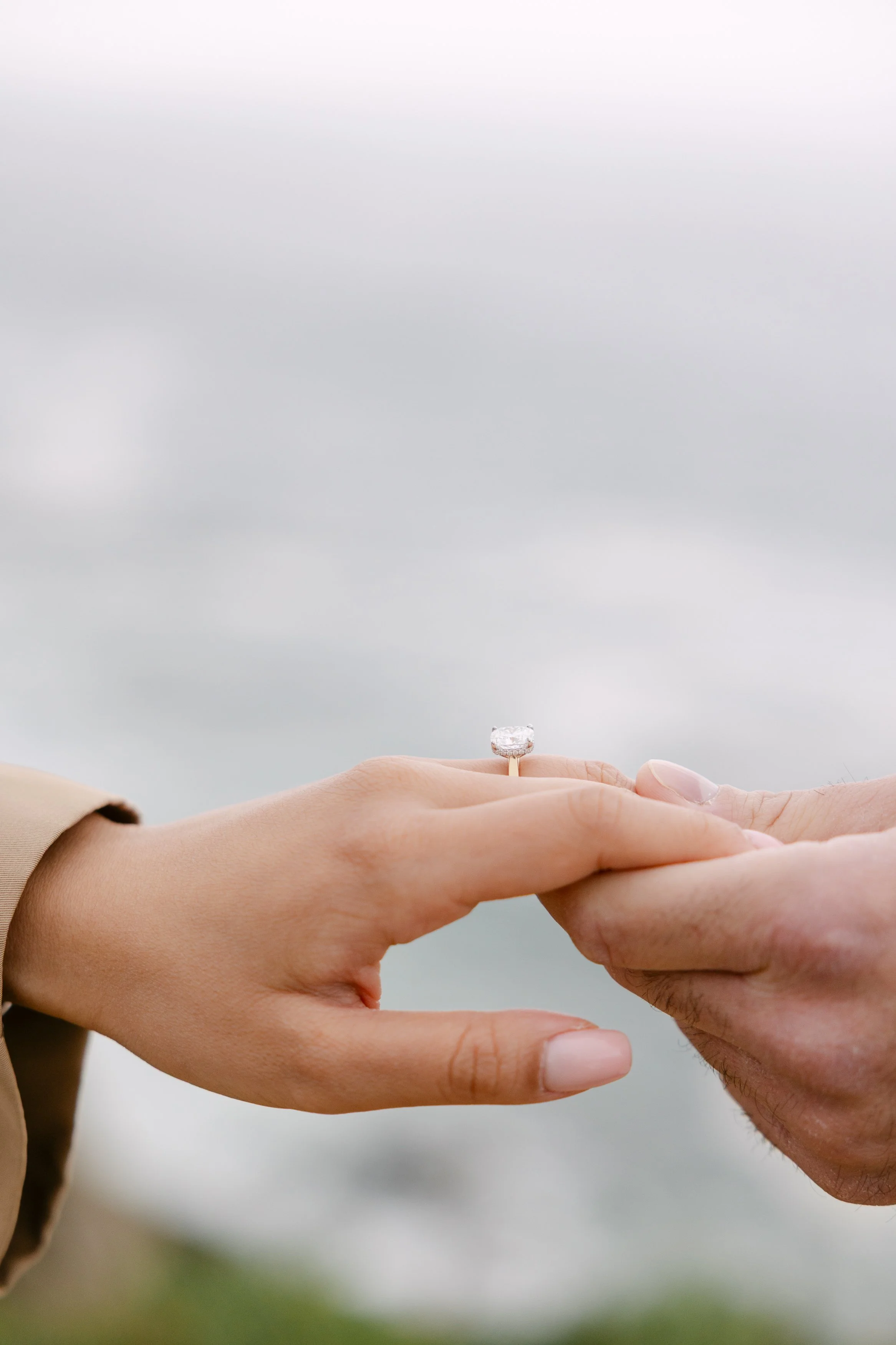 Close-up of engagement ring during romantic coastal proposal photoshoot in Portugal.