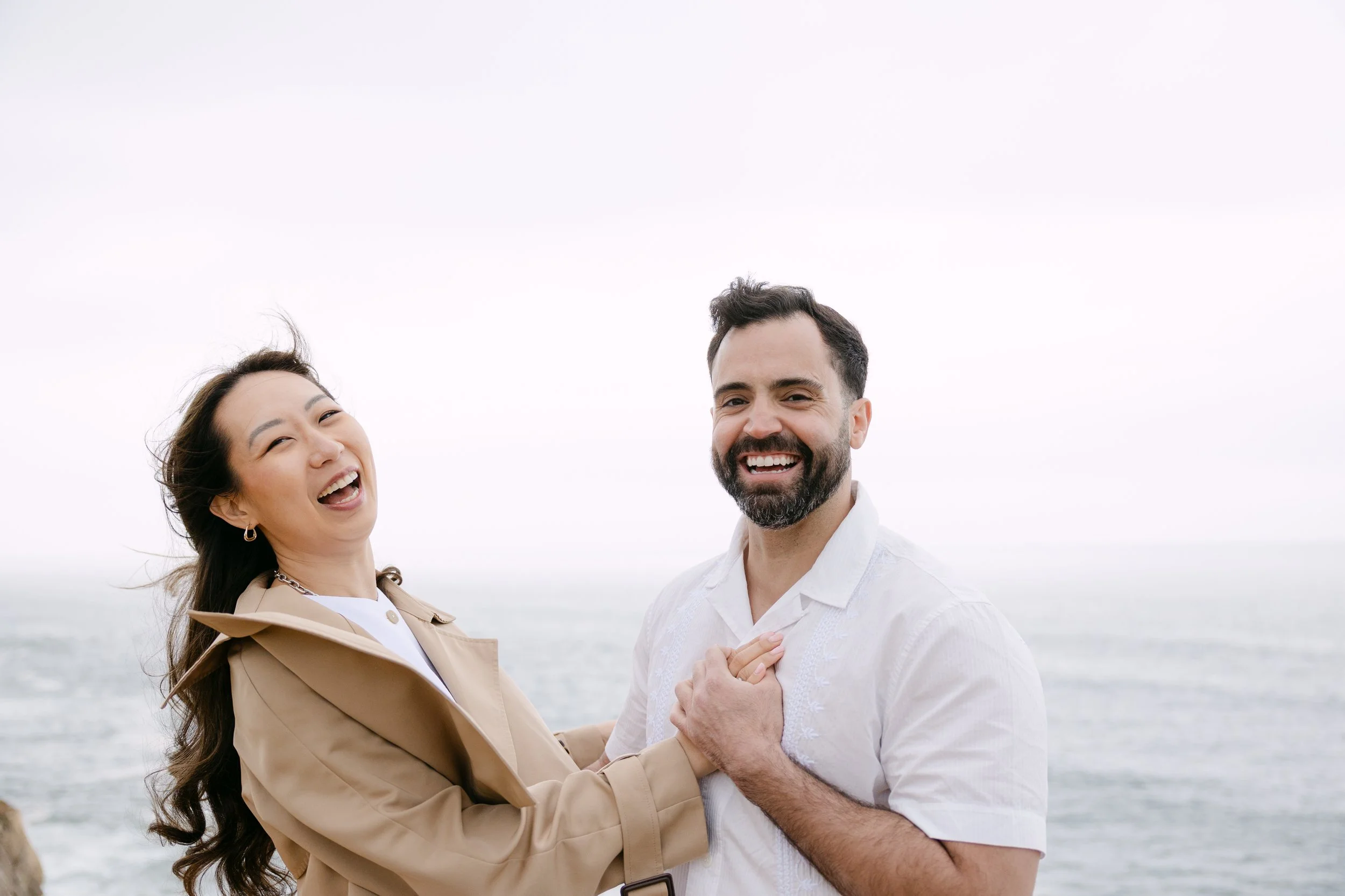 Fun portrait of engaged couple with coastal views in Azenhas do Mar during engagement session.