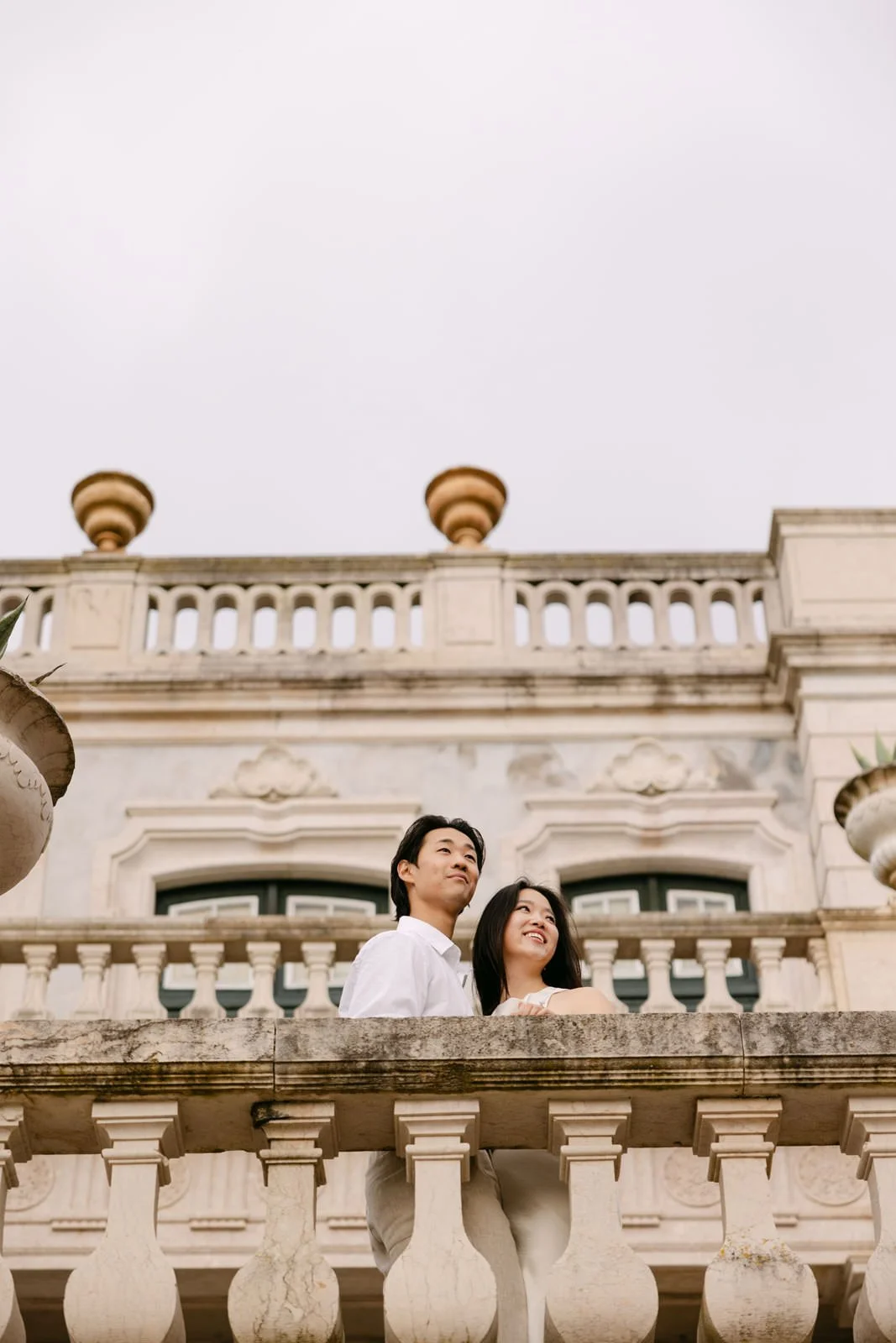 Wide portrait of engaged couple on the grand staircase of Palácio de Queluz.