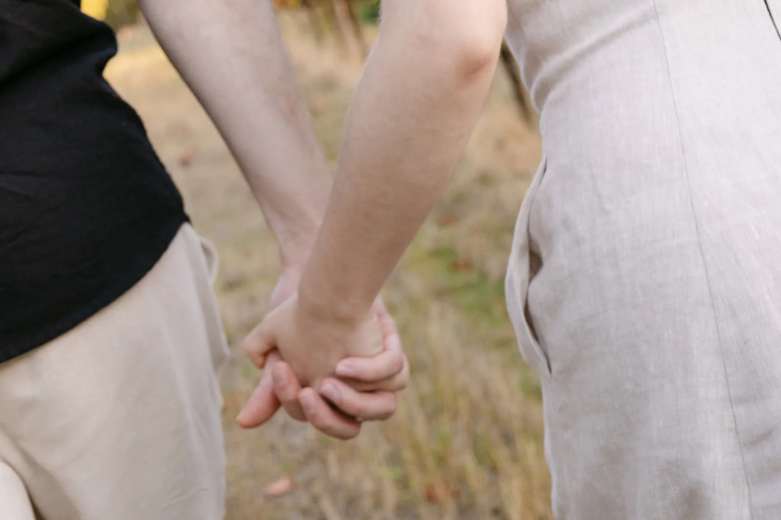 Close-up of a newly engaged couple holding hands while walking through the vineyards at Quinta de Sant’Ana near Lisbon.