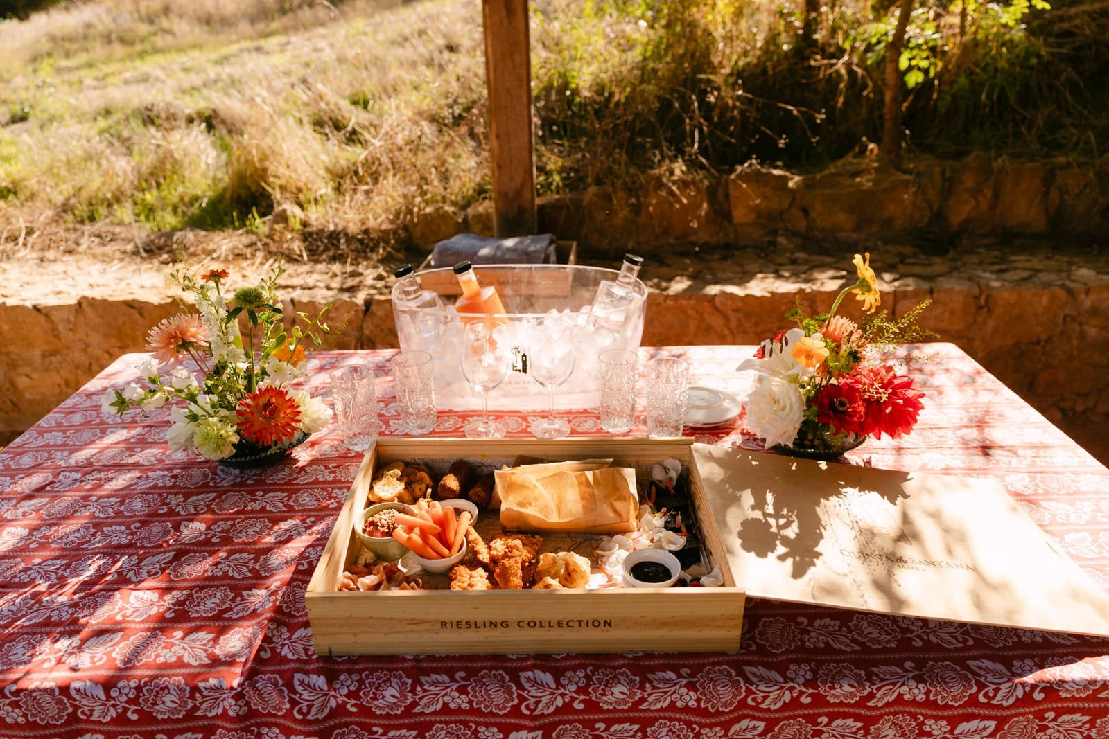 Picnic table decorated with colourful flowers, drinks and food for a private surprise proposal at Quinta de Sant’Ana in Portugal.