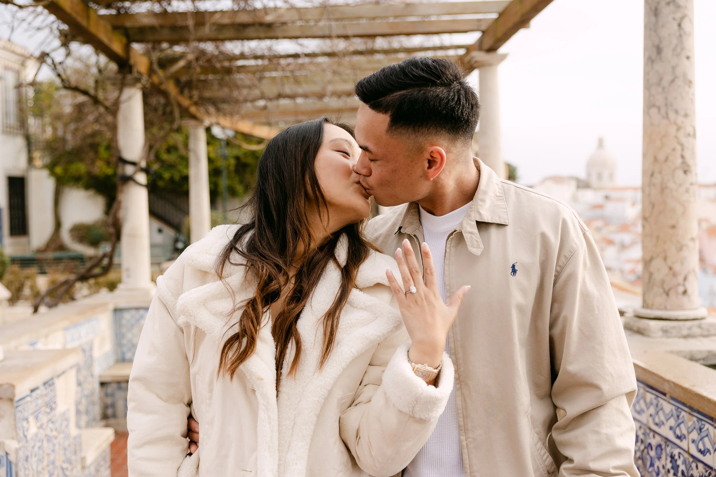 Couple kissing after surprise proposal at Santa Luzia viewpoint in Lisbon