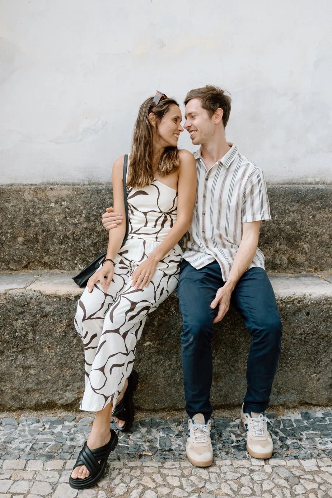 Recently engaged couple sharing a quiet moment together after a surprise proposal in Sintra Village, Portugal.