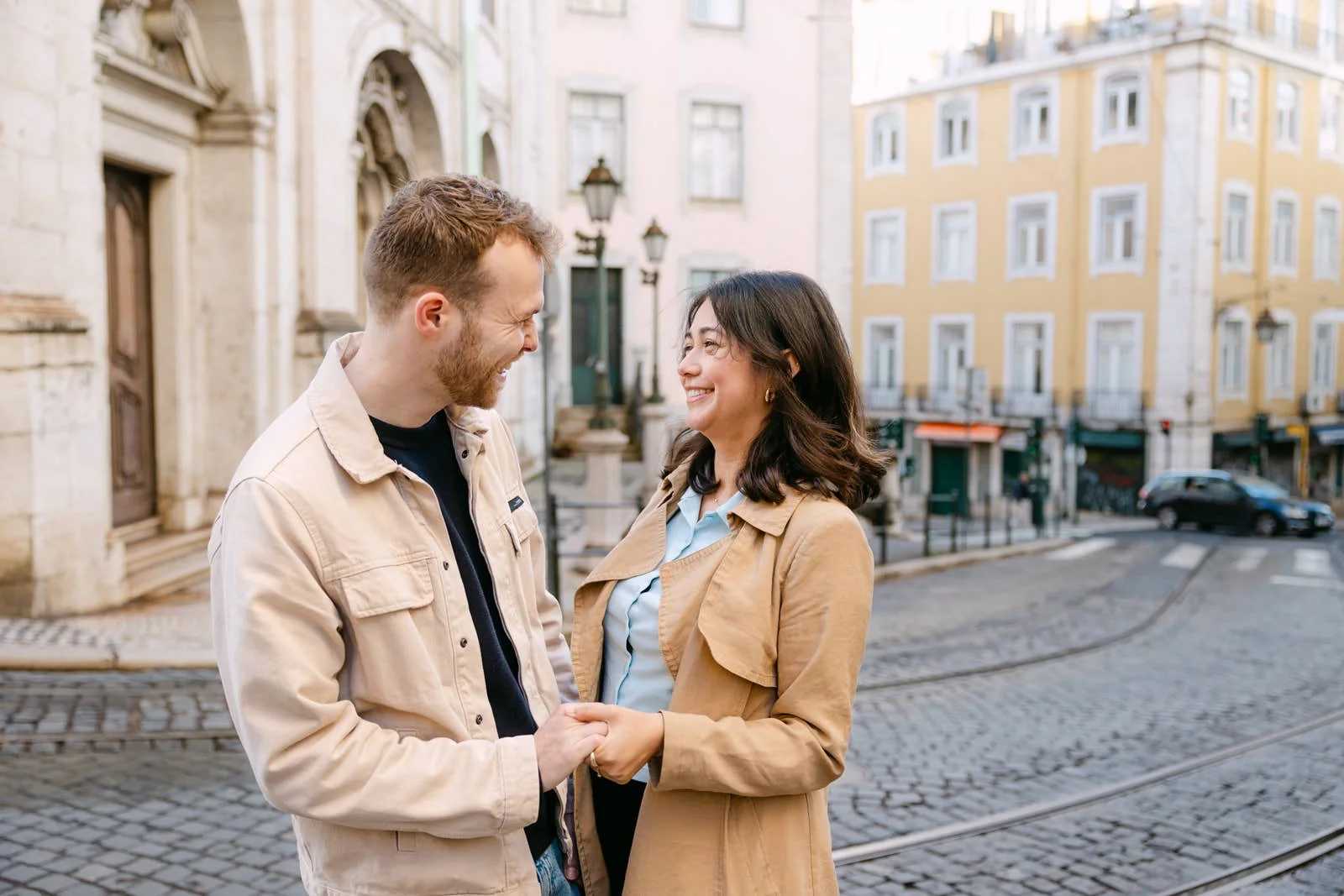 Engaged couple smiling together in the historic streets of Alfama Lisbon