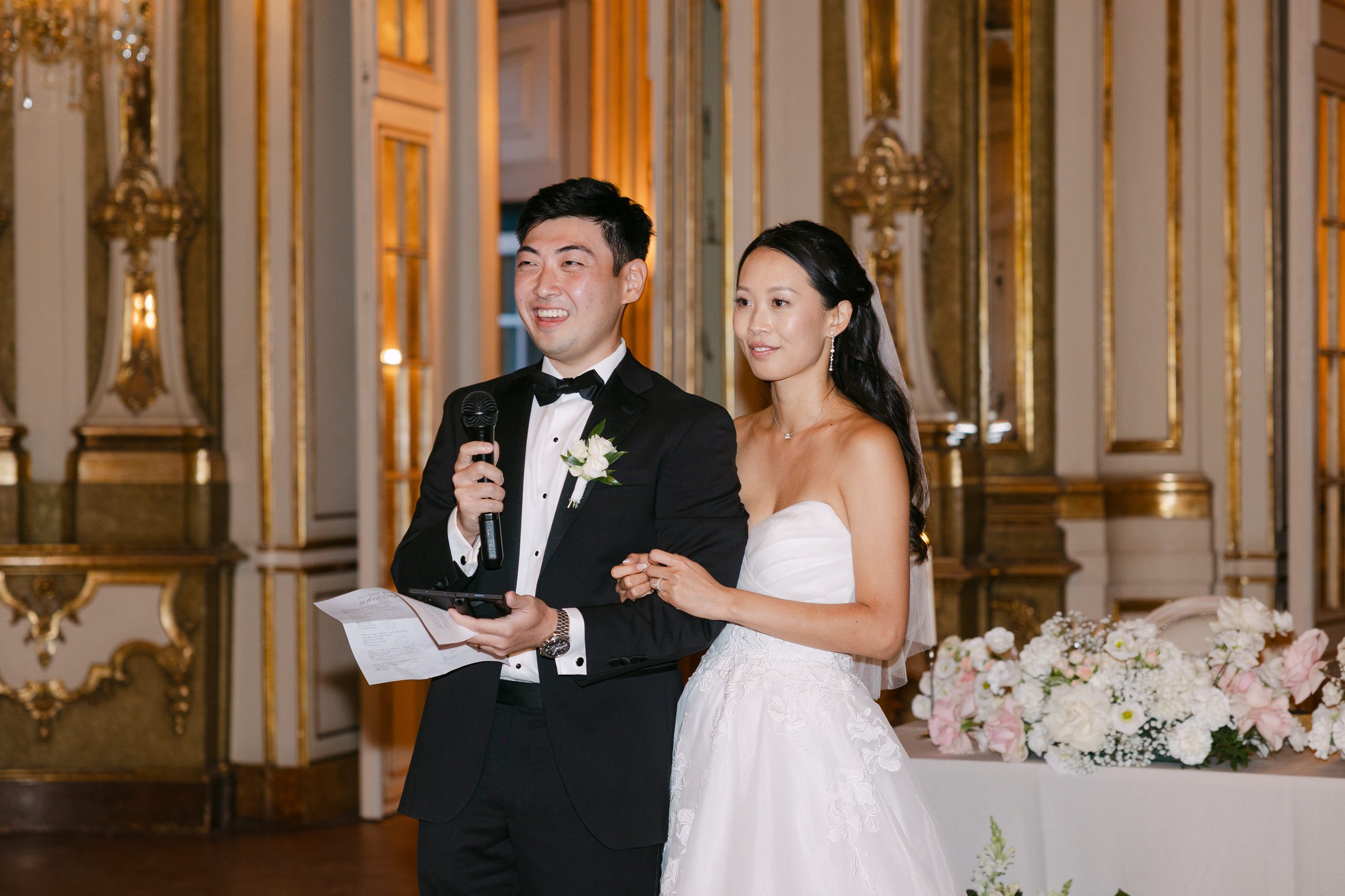 Bride and groom standing together and giving a speech during their elegant wedding reception inside Palácio Nacional de Queluz.