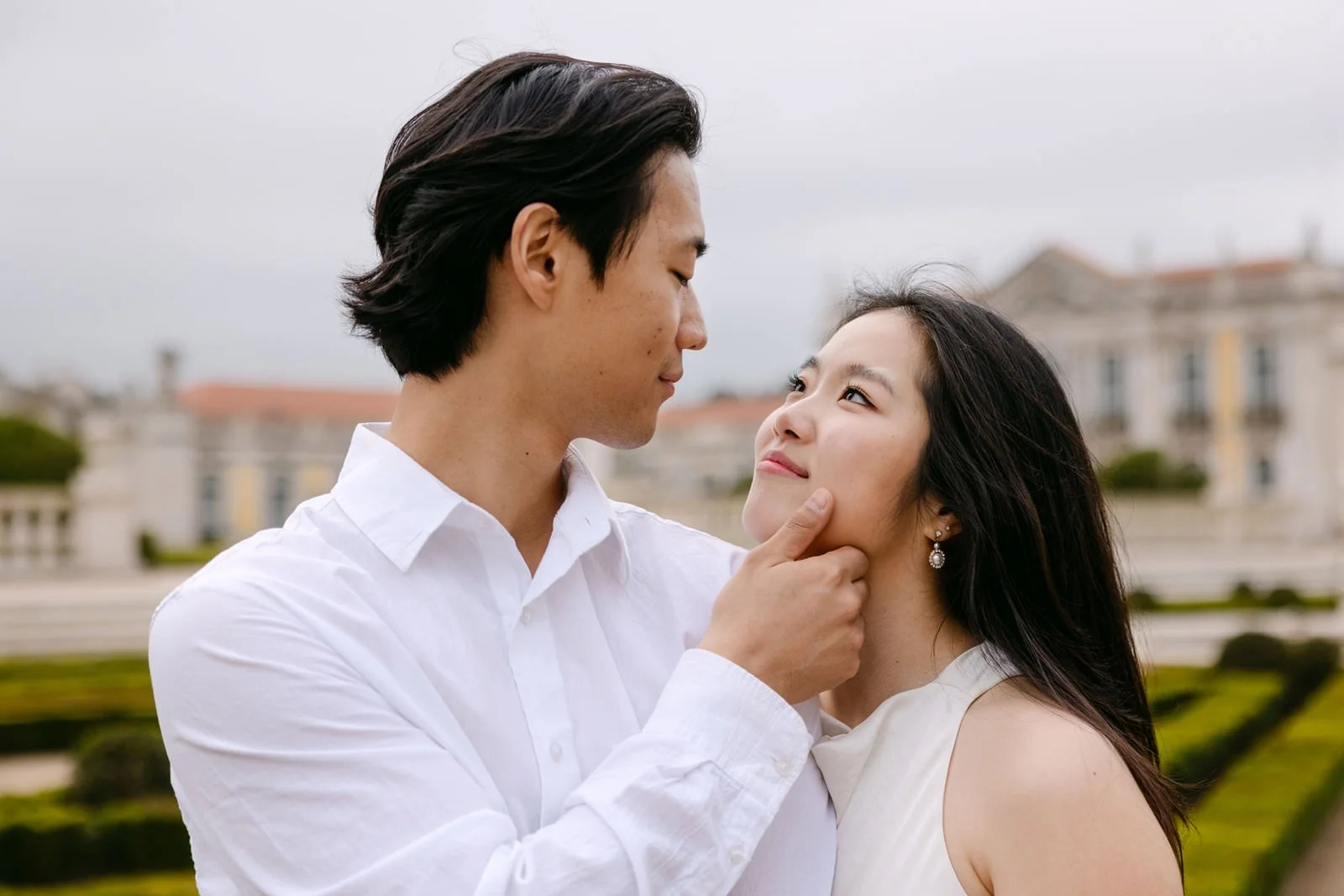 Couple standing in front of the historic facade of Palácio de Queluz during engagement photos.
