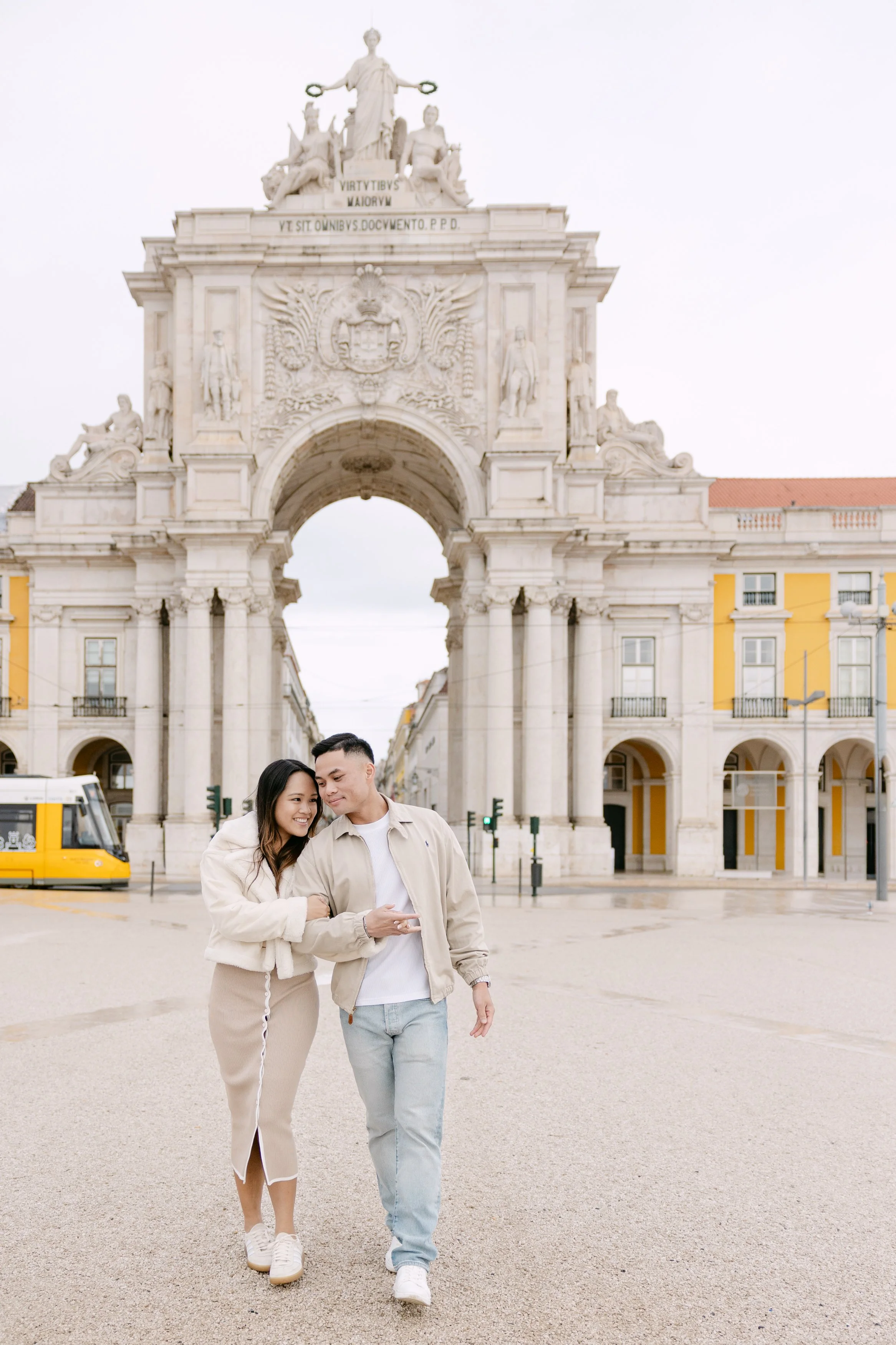 Couple walking together at Praça do Comércio during engagement session in Lisbon