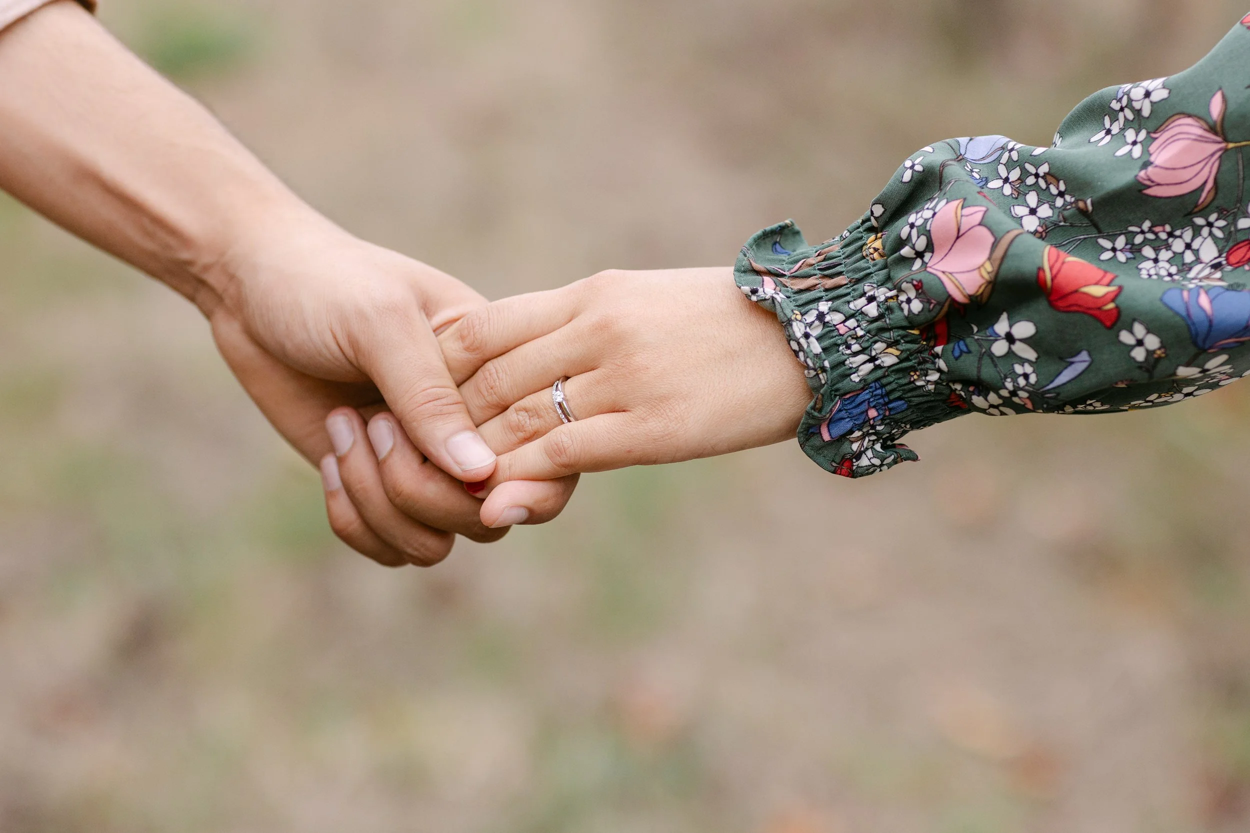 Couple holding hands showing engagement ring at vineyard engagement session in Portugal