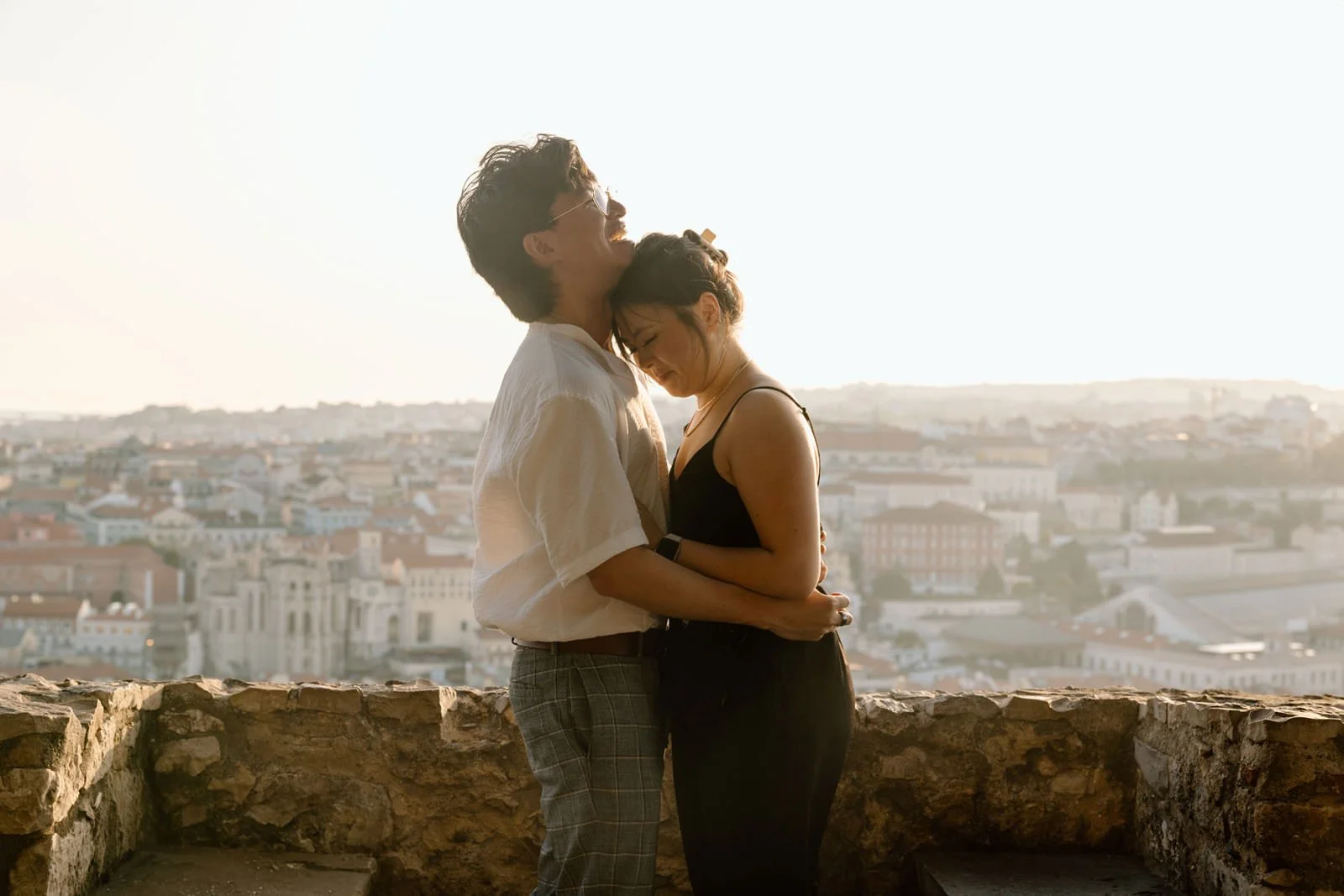 Newly engaged couple embracing during an engagement photoshoot at Castelo de São Jorge in Lisbon.