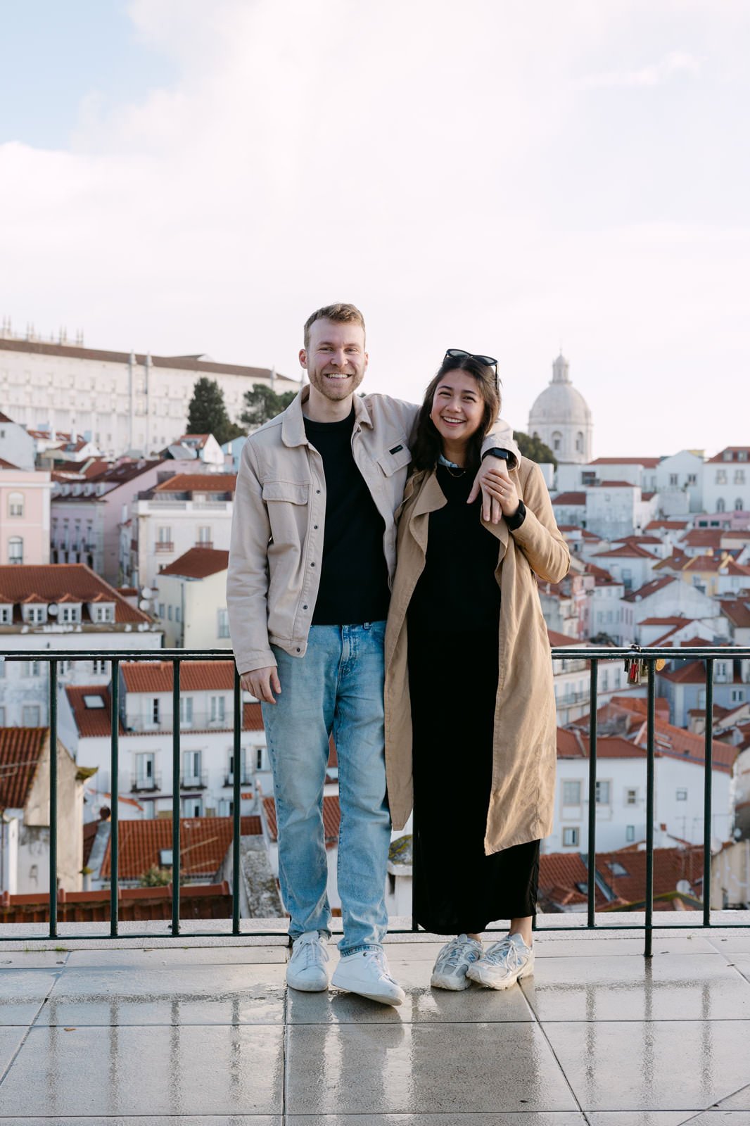 Recently engaged couple posing at Miradouro das Portas do Sol in Lisbon