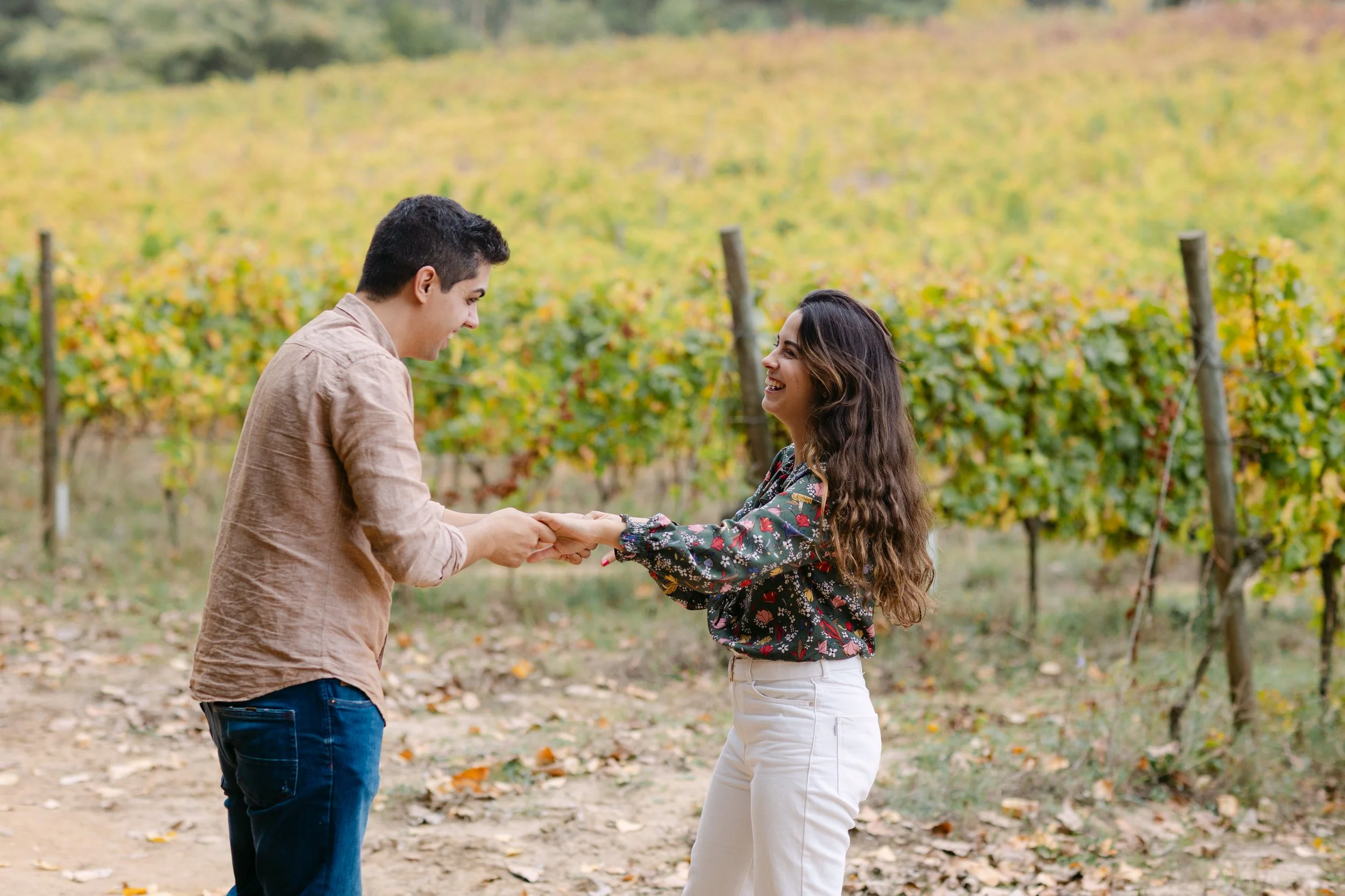 Couple holding hands during vineyard engagement session in Portugal