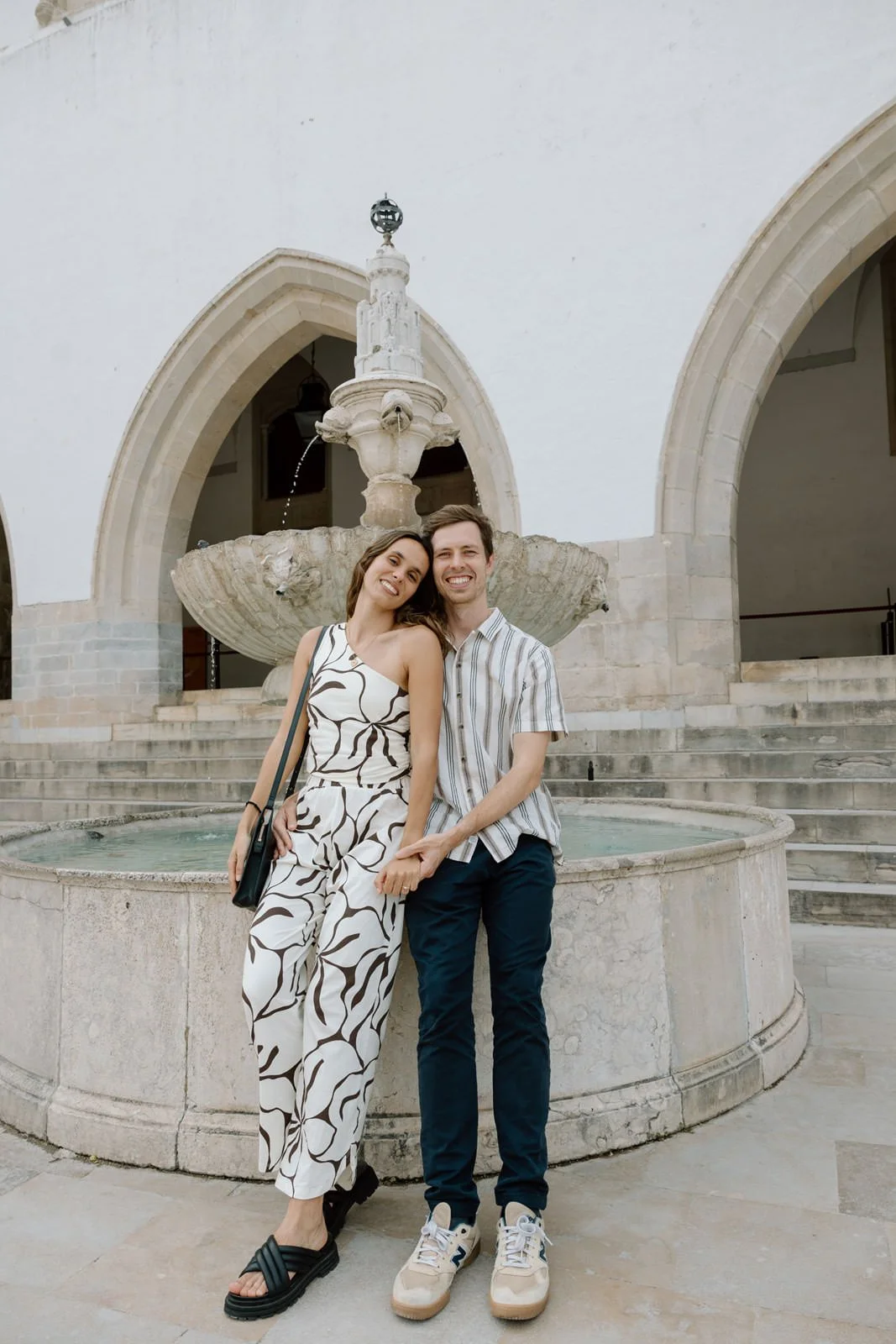 Couple celebrating their engagement beside the fountain courtyard at Palácio Nacional de Sintra.