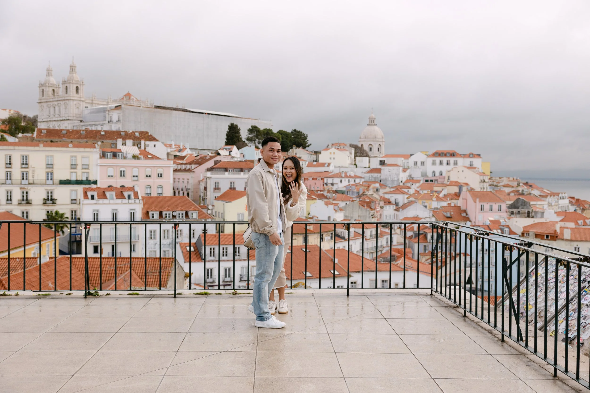 Recently engaged couple showing ring at Miradouro das Portas do Sol in Lisbon