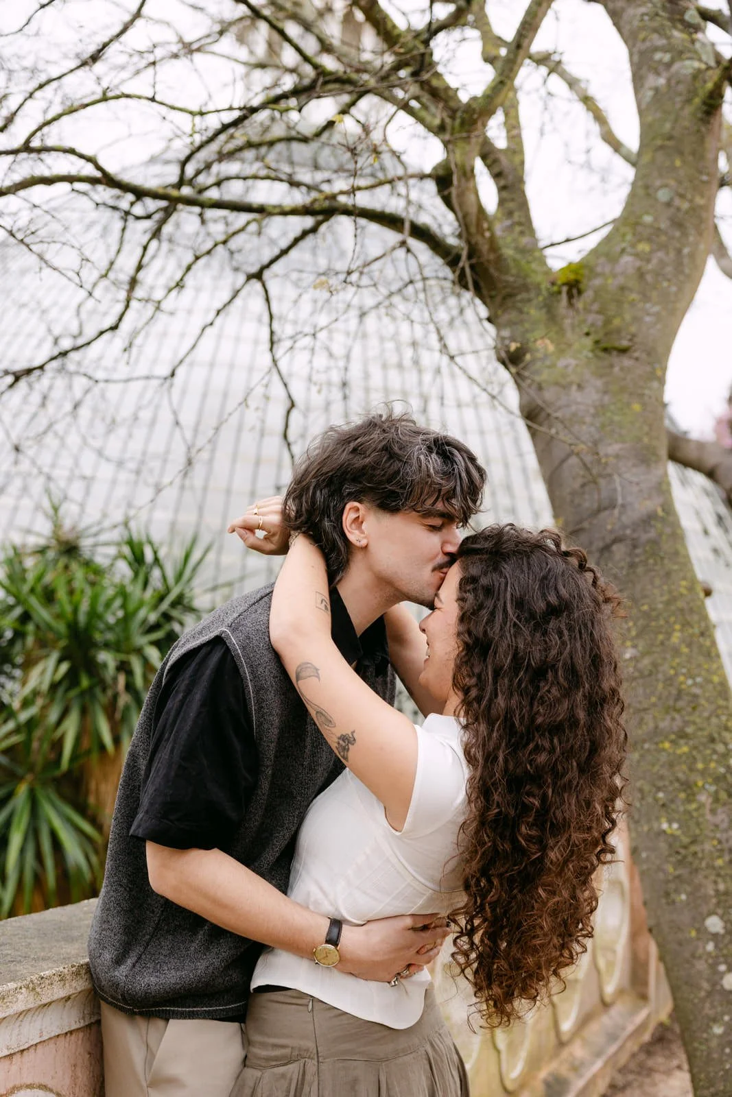 Couple embracing beneath a tree during an engagement session at Tapada das Necessidades